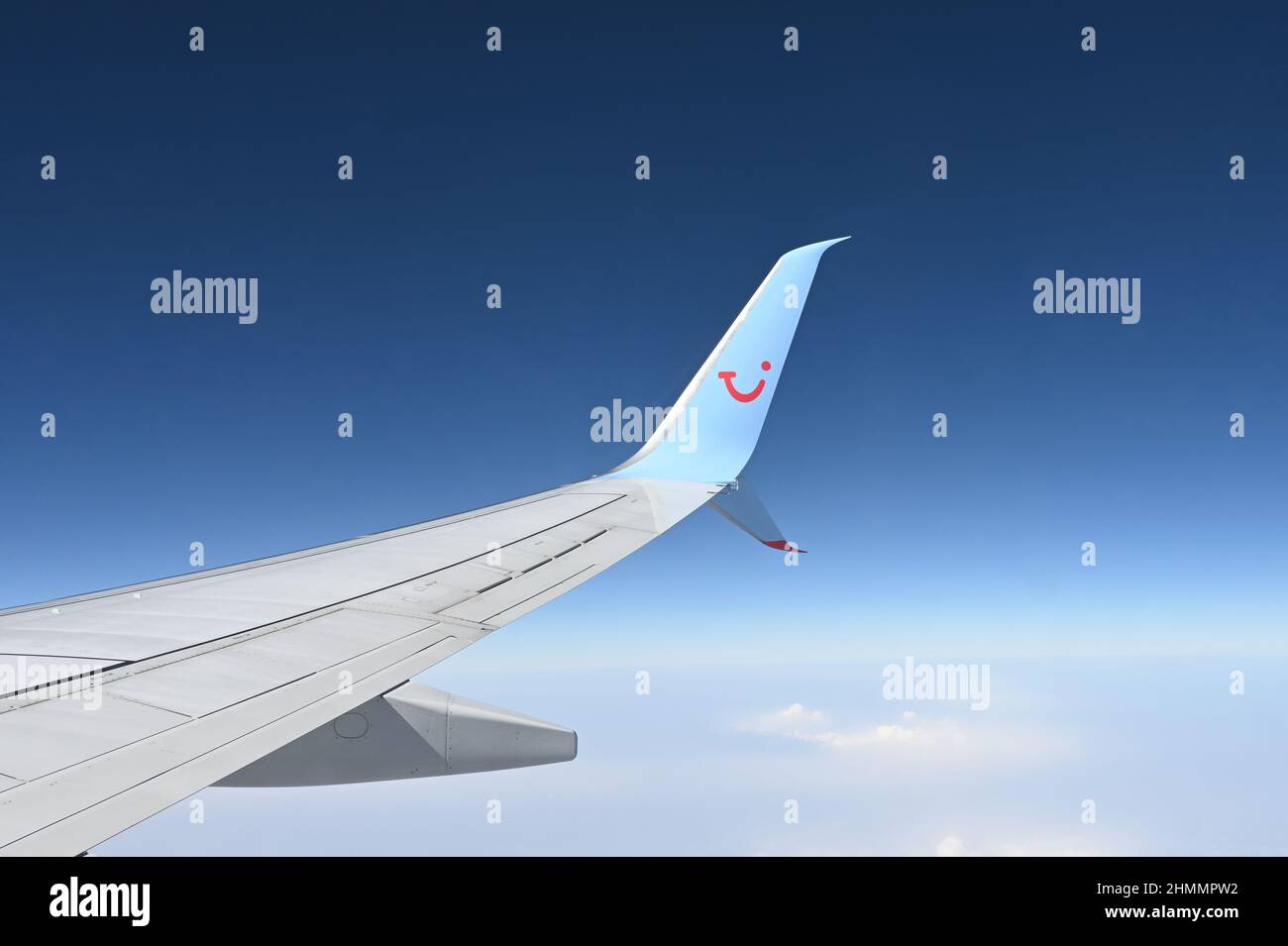 Une aile d'un Boeing 737 TUI affrété avion pris en vol montrant la clarté du ciel bleu et des nuages dispersés ci-dessous Banque D'Images