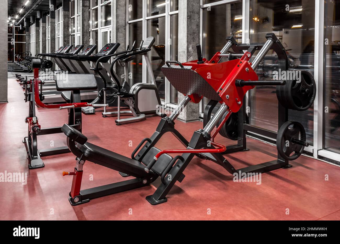 Machines d'exercice pour renforcer les muscles de la presse, des jambes et  du dos dans l'intérieur vide spacieux de la salle de gym. Tapis roulants  modernes près de la fenêtre. Sport, fitness
