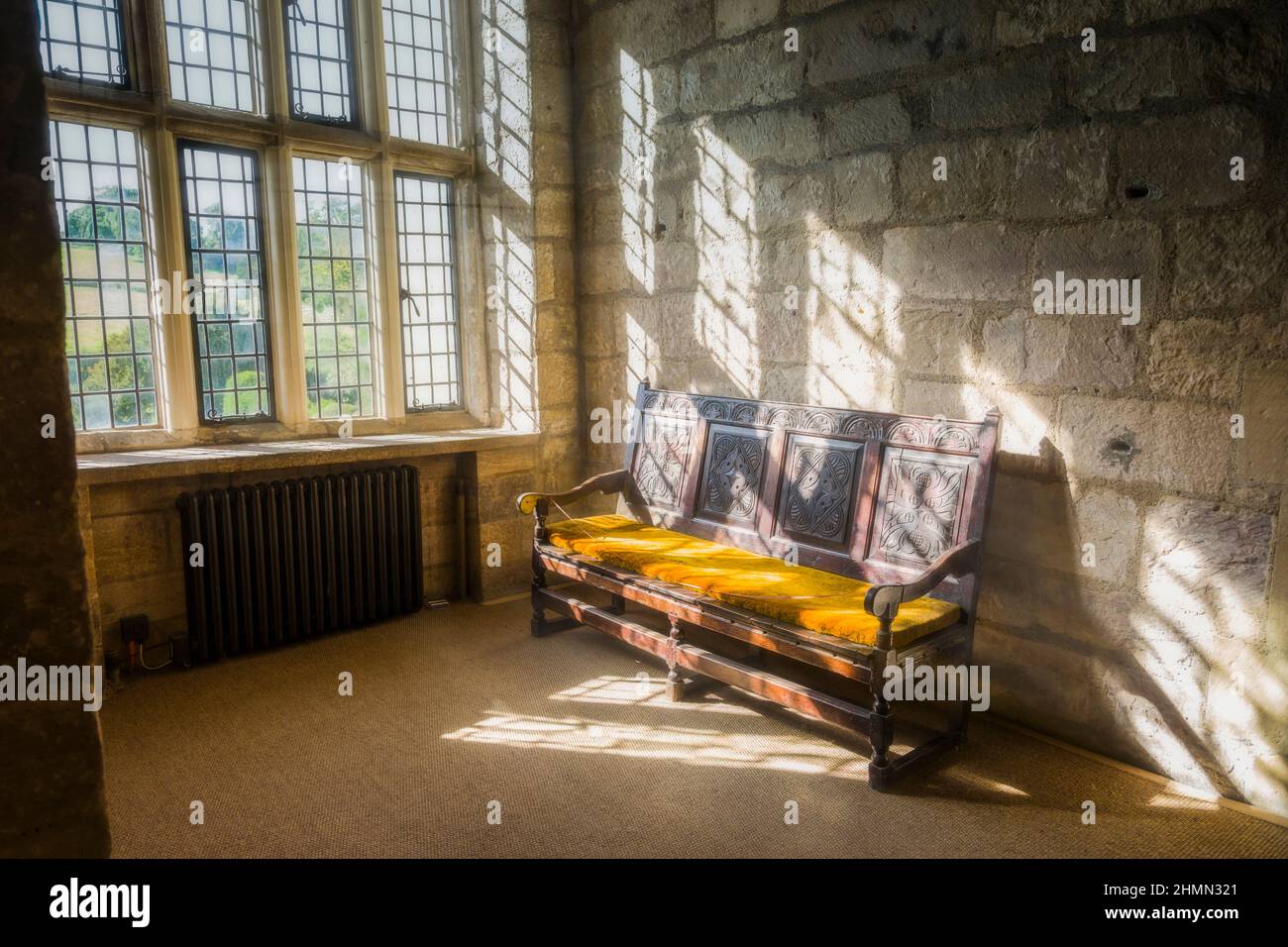 Banc en chêne dans un coin ensoleillé, image de l'intérieur. Banque D'Images