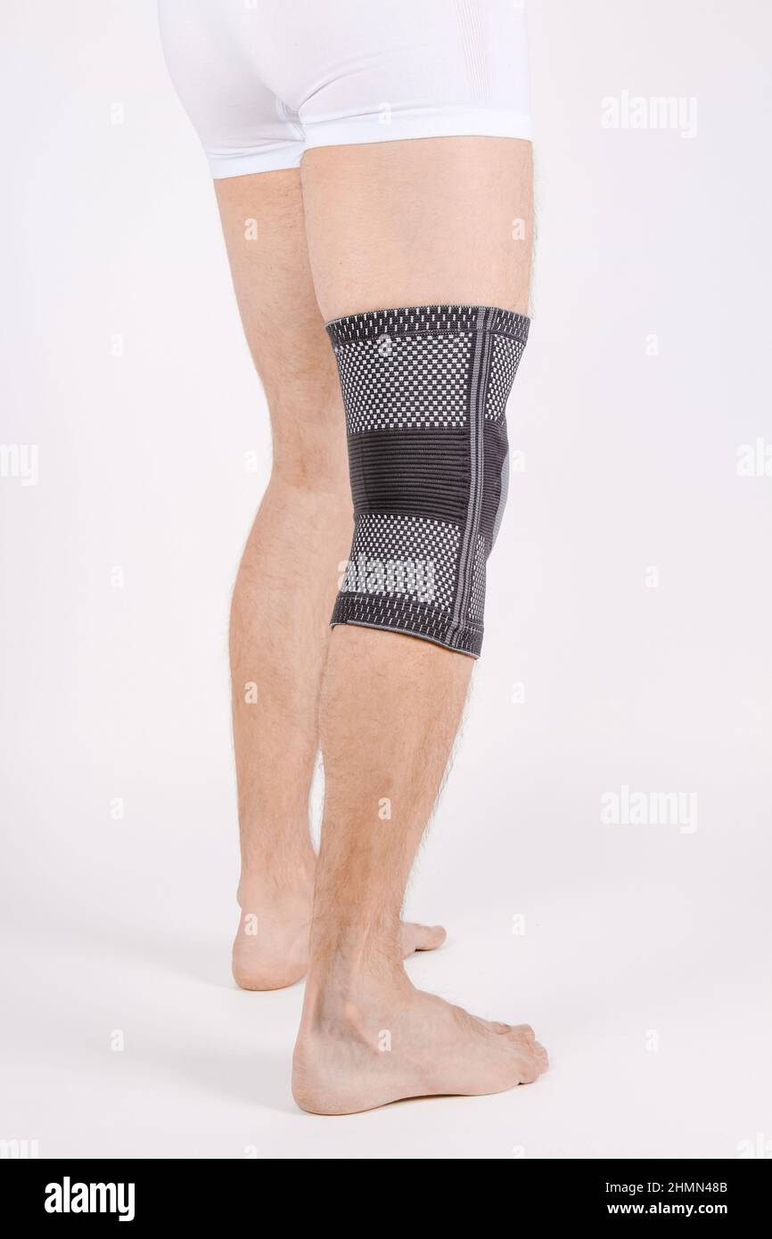 Renfort de support de genou sur la jambe isolé sur fond blanc. Orthèse  orthopédique élastique. Bretelles anatomiques pour la fixation du genou,  les blessures et la douleur. Protection Photo Stock - Alamy
