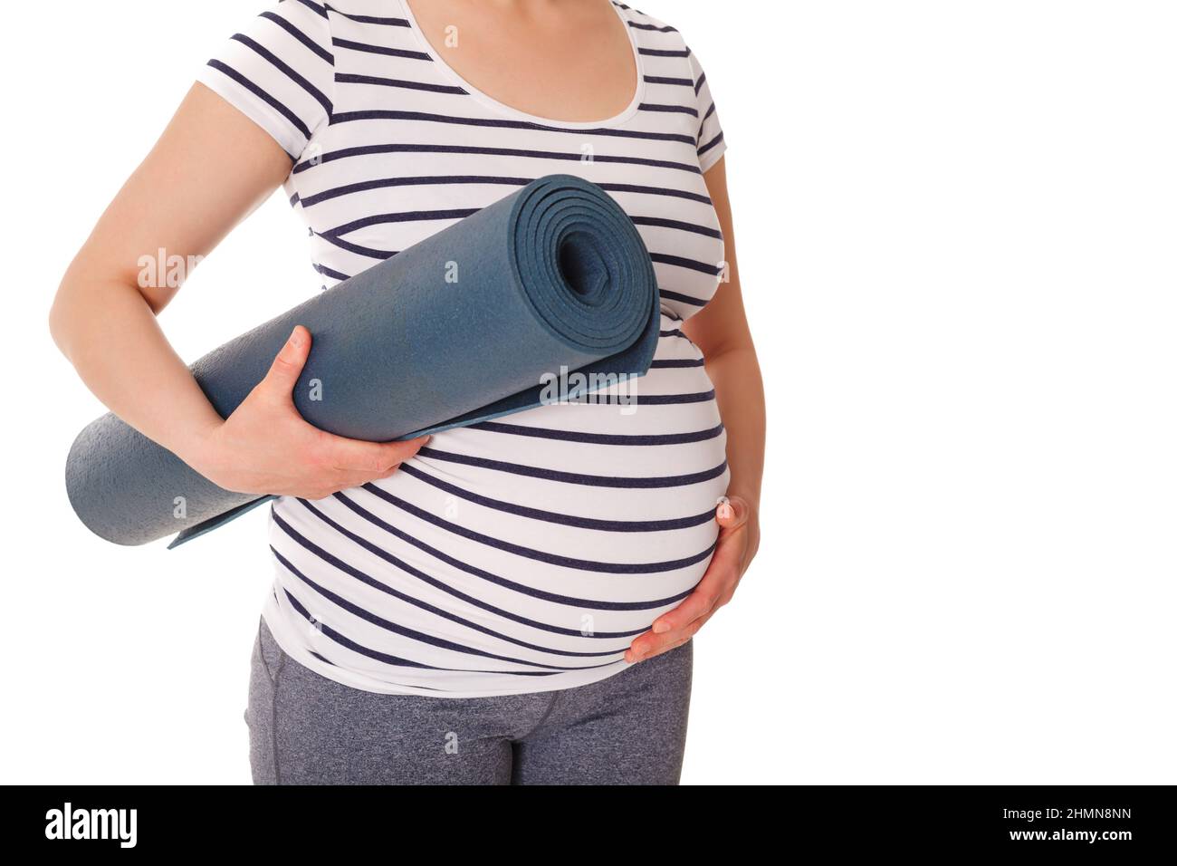 Femme enceinte debout avec un tapis de yoga Banque D'Images