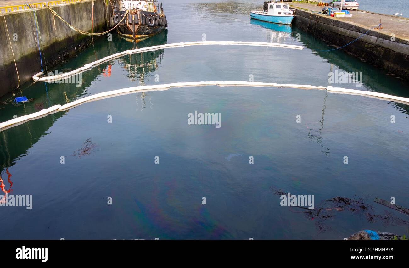 Les flèches anti-pollution par les hydrocarbures retiennent l'eau polluée par le diesel. Keelbeg Pier, Union Hall, West Cork, Irlande Banque D'Images