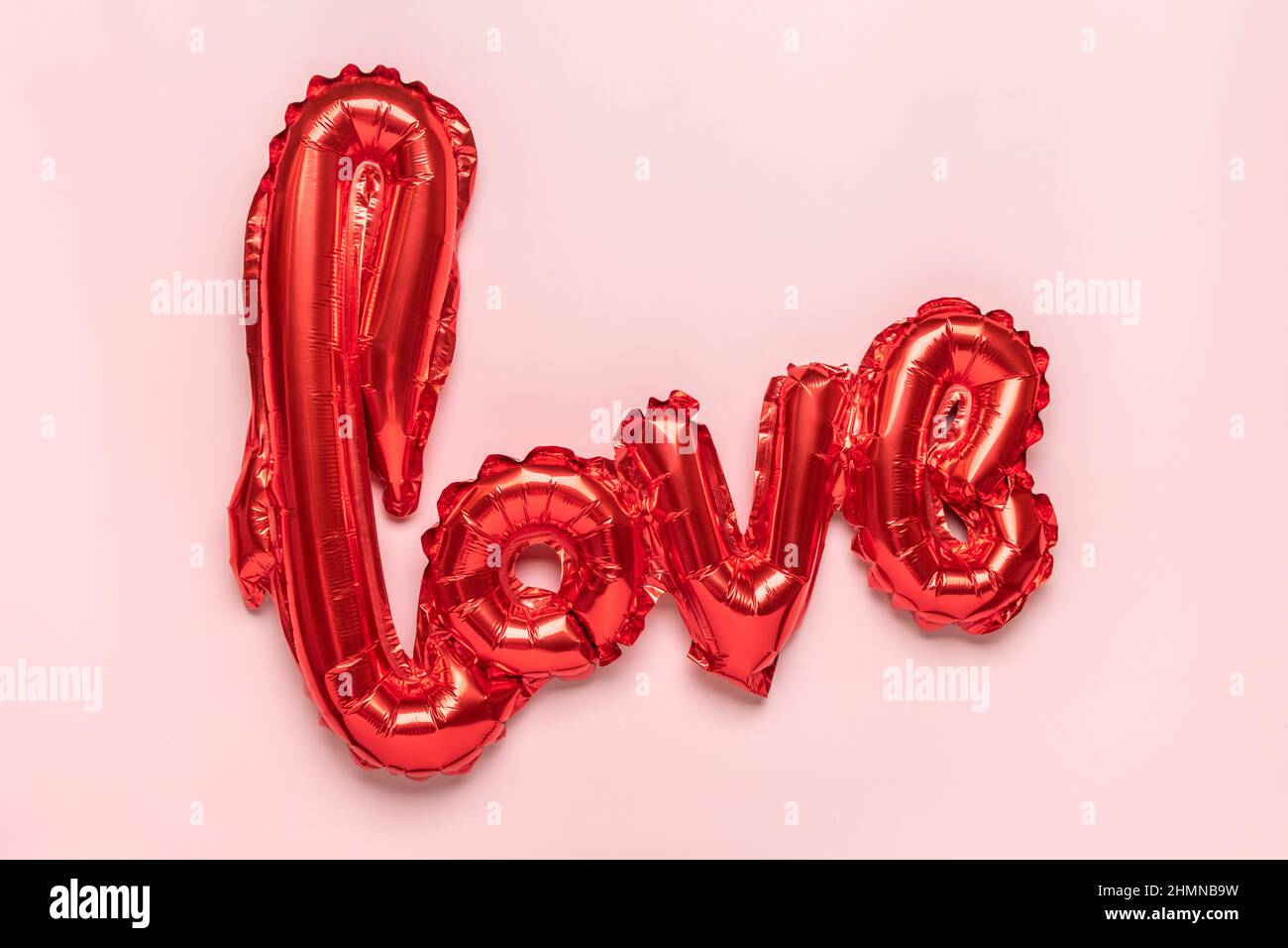 Lettres gonflables amour dans la couleur rouge isolé sur fond rose plat Lay Top View carte de vacances, Happy Valentines Day concept Amour dans l'air Banque D'Images