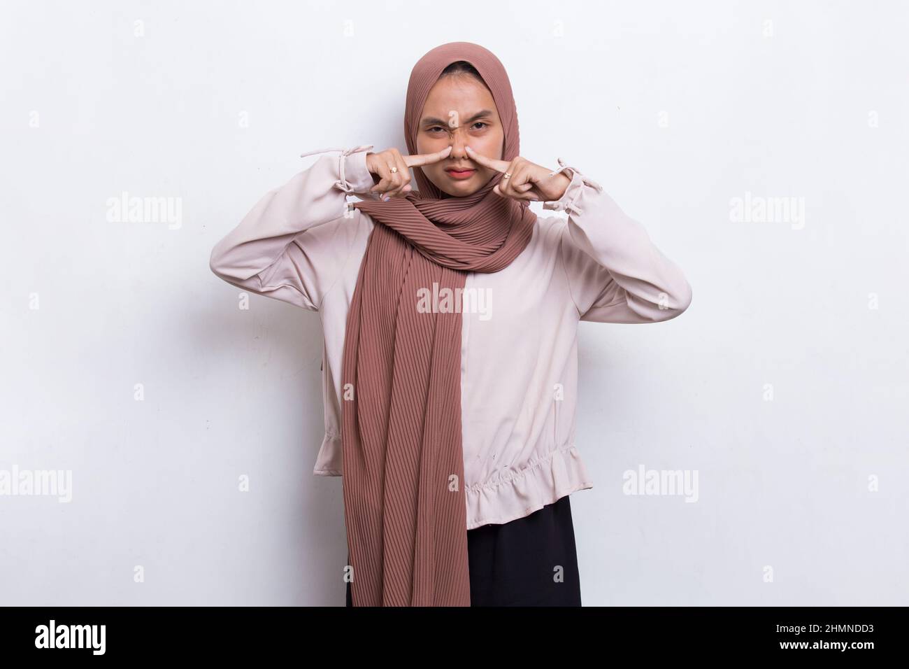 jeune asiatique belle femme musulmane tenant son nez à cause d'une mauvaise  odeur Photo Stock - Alamy