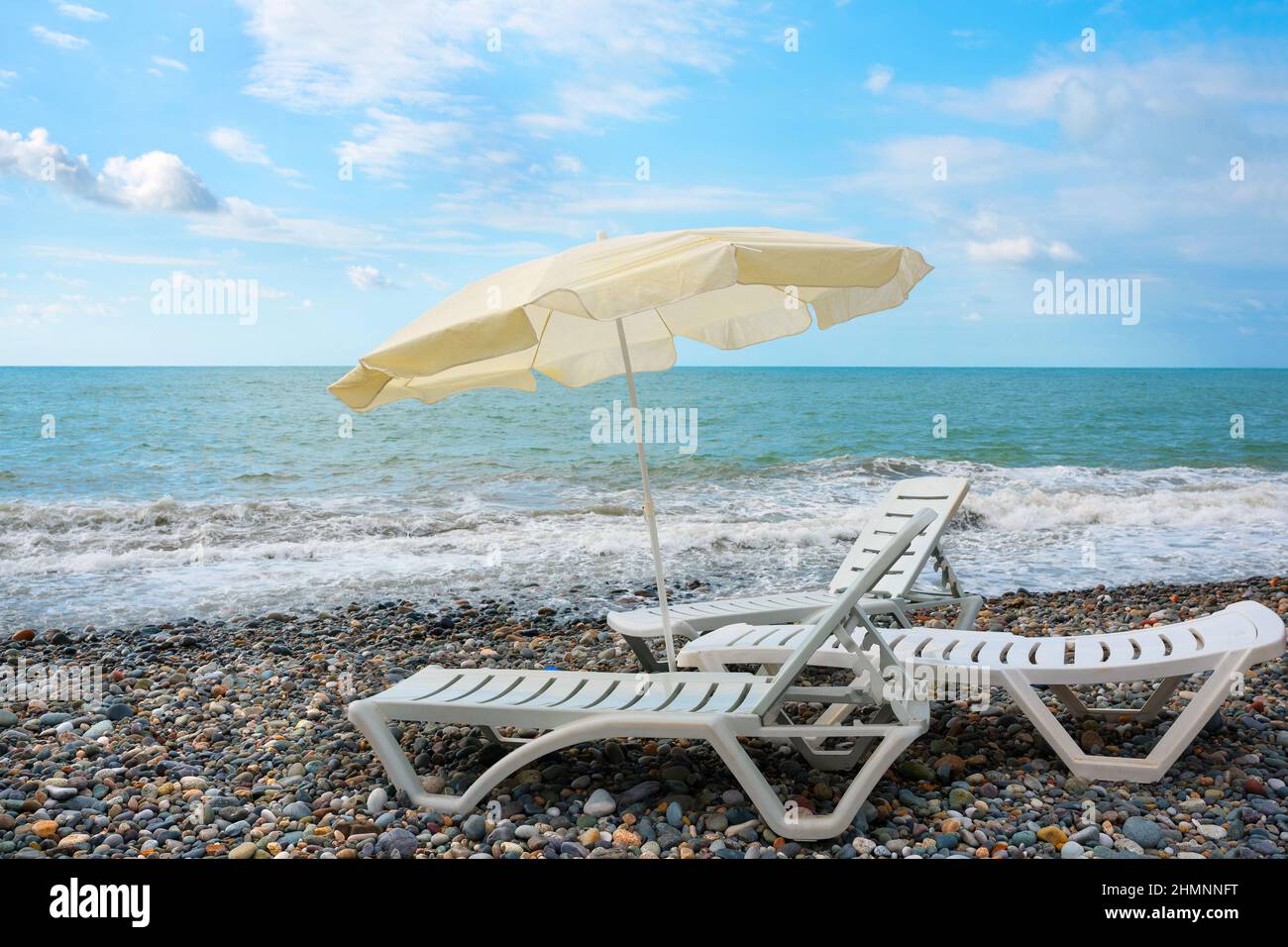 Chaises longues et parasol, mer à terre. Fond de voyage. Chaise de plage sur la plage. Banque D'Images