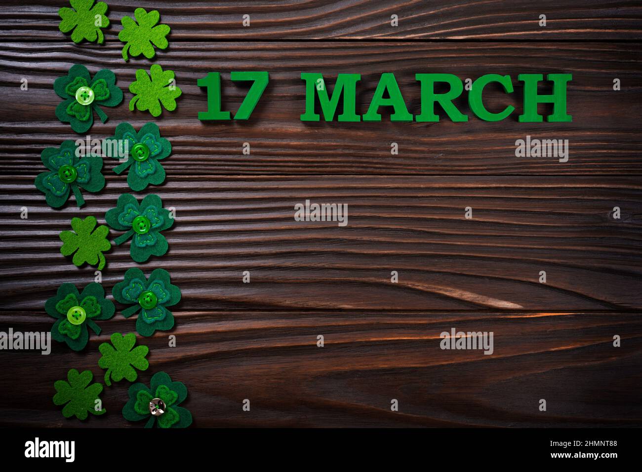 Des feuilles de Shamrock faites à la main sur fond de bois sombre avec vue sur les plans à plat de l'espace pour les copies Banque D'Images