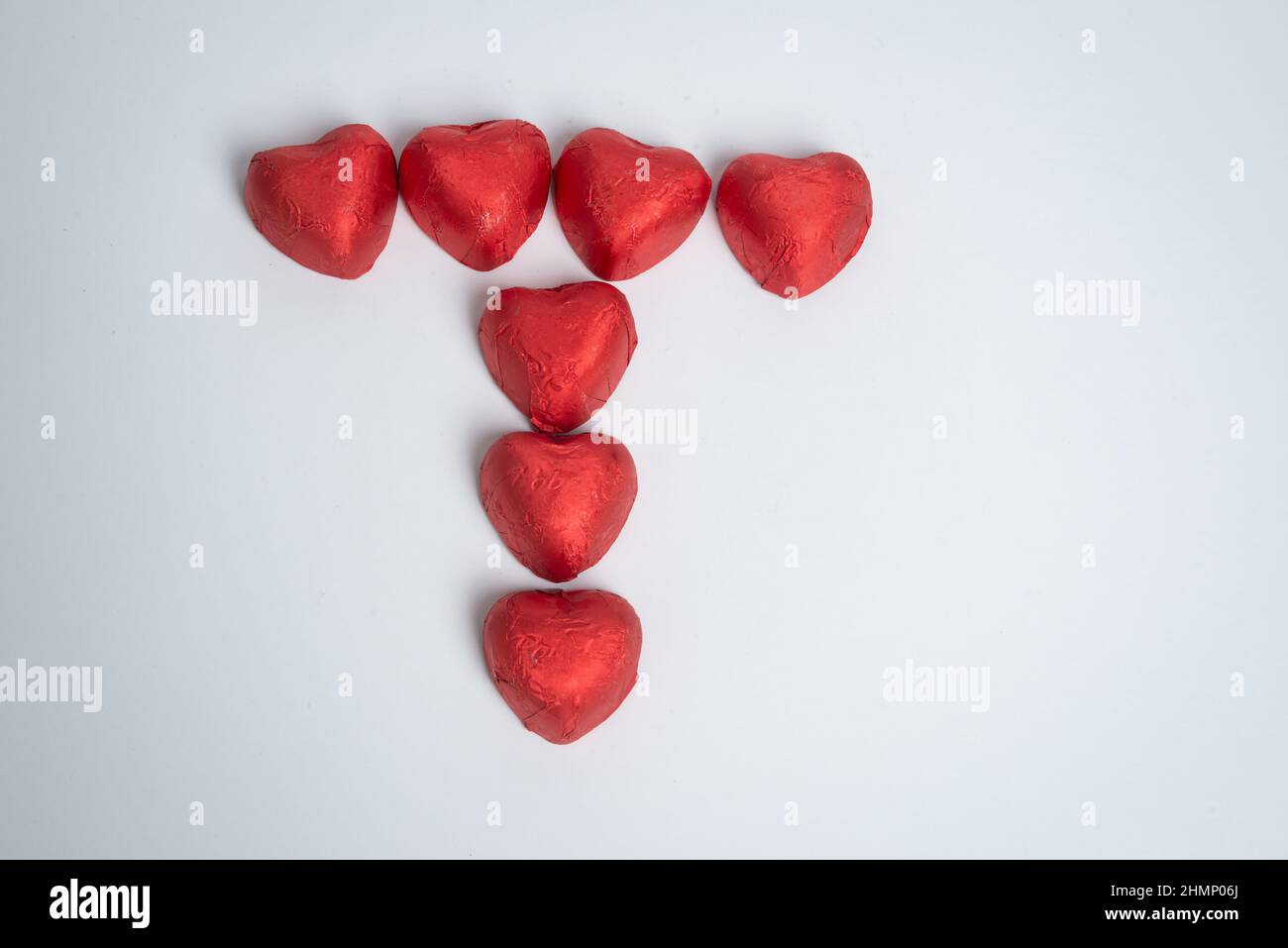 Bonbons coeur rouge chocolat en forme de lettre T pour la Saint-Valentin sur fond blanc Banque D'Images