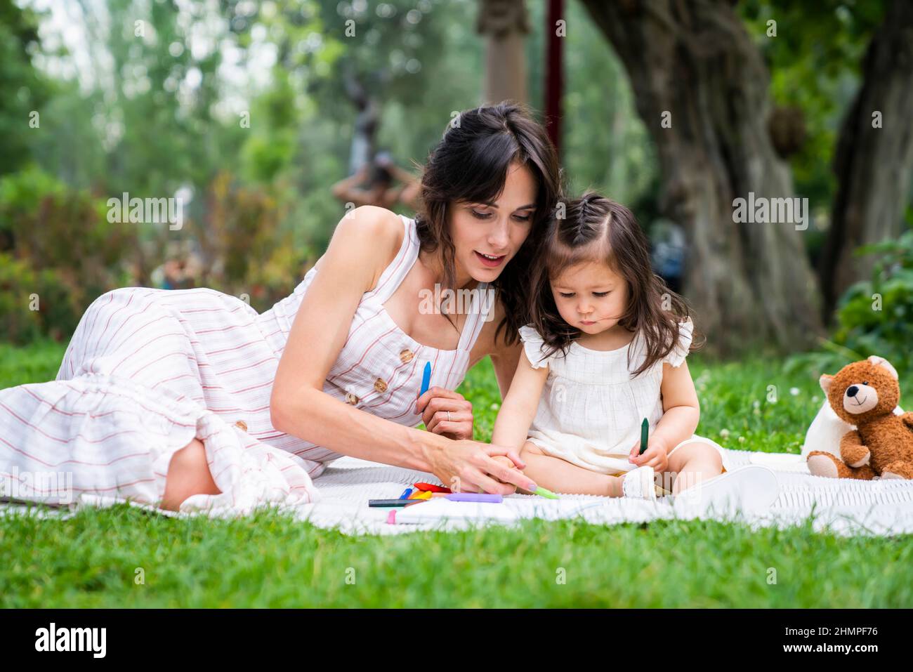 Mère avec une fille tout-petit ayant le repos au parc Banque D'Images