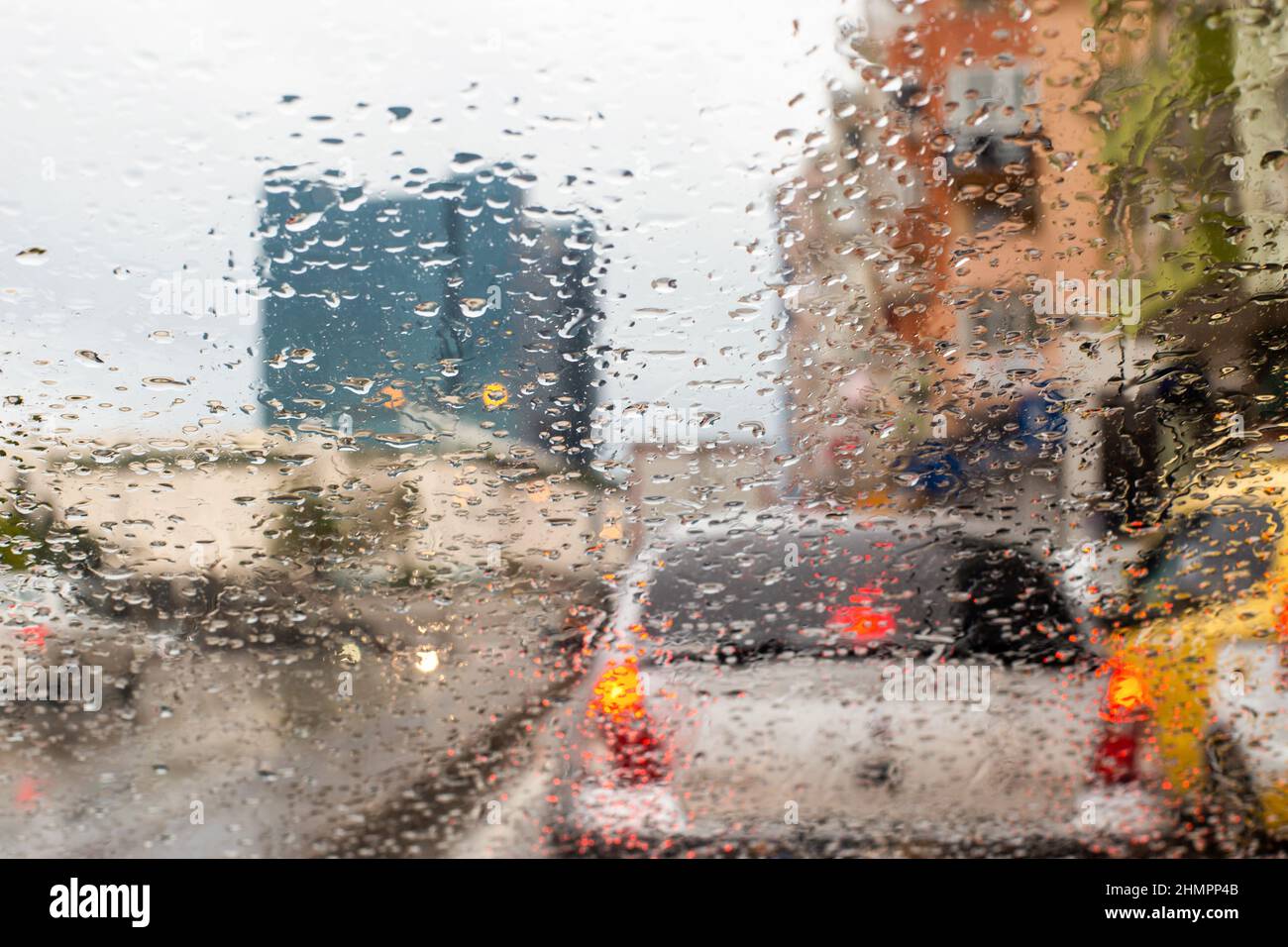 Des gouttes s'accumulent sur la vitre de la voiture par temps pluvieux et la vue extérieure depuis la vitre Banque D'Images