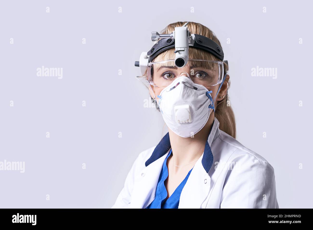 Médecin ORL confiant portant un phare chirurgical et des lunettes de protection. Portrait d'une otolaryngologiste féminine ou d'un chirurgien de la tête et du cou Banque D'Images