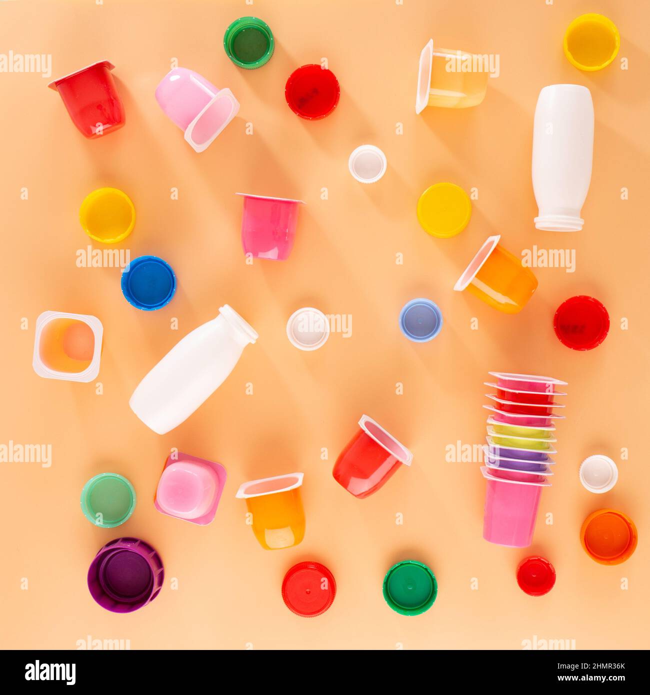 un ensemble de pots de yaourt à emballage multicolore, des tasses en plastique vides, une vue de dessus, un fond orange, des idées pour la classe de maître avec les enfants Banque D'Images