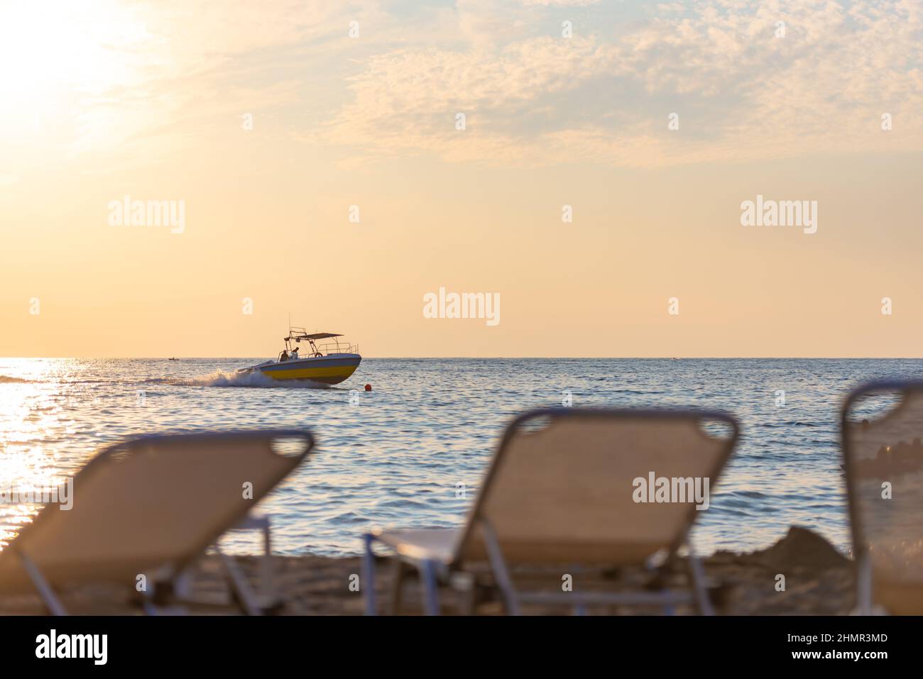 Les dos des chaises longues en face de la mer avec un bateau. Soirée sur la plage. Concentrez-vous sur le bateau. Banque D'Images