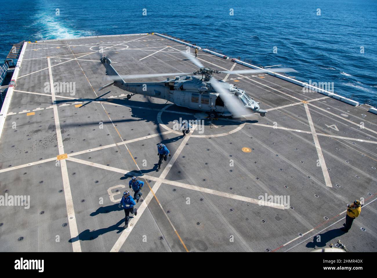 20220205-N-WY048-1034 OCÉAN PACIFIQUE (FÉV 5, 2022) – les marins affectés au quai de transport amphibie USS Anchorage (LPD 23) calent et enchaîdent un MH-60s Seahawk attaché aux « Blackjacks » de l’Escadron de combat de la mer (HSC) 21 au pont de vol du navire, 5 février. Anchorage mène actuellement des opérations de routine dans le parc US 3rd. (É.-U. Navy photo par Mass communication Specialist 2nd Class Hector Carrera) Banque D'Images