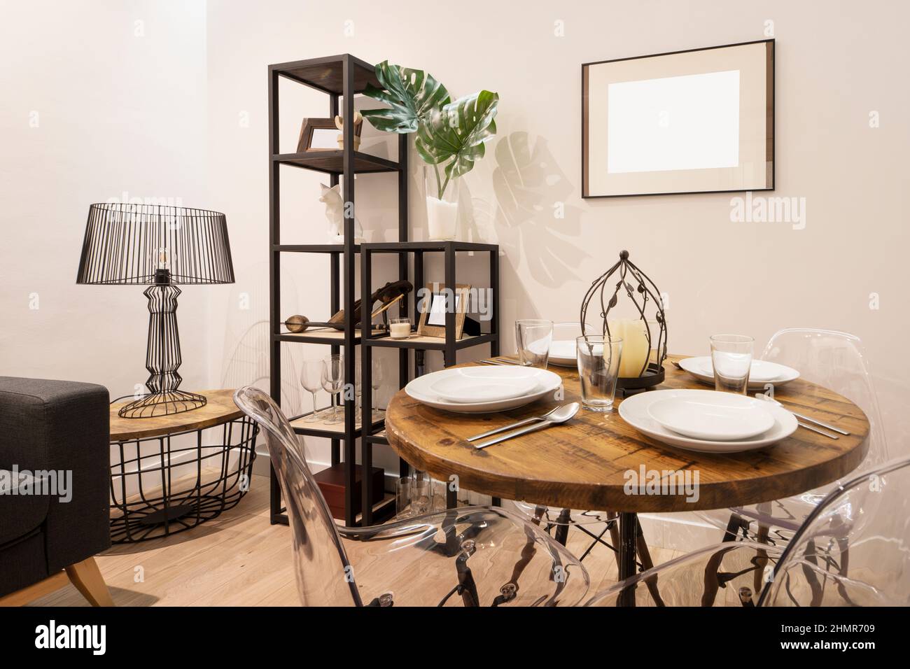 Salle de séjour avec décoration éclectique et quelque peu chaotique avec table ronde en bois et service de restauration Banque D'Images