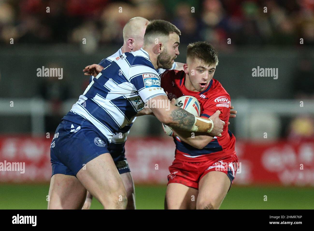 Mikey Lewis #20 de Hull KR est attaqué par Kaide Ellis #15 et Sam Powell #9 de Wigan Warriors Banque D'Images