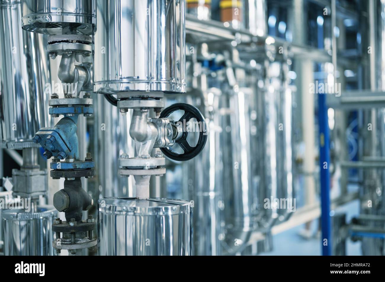 Grand tube avec petite vanne noire à l'usine de production Banque D'Images
