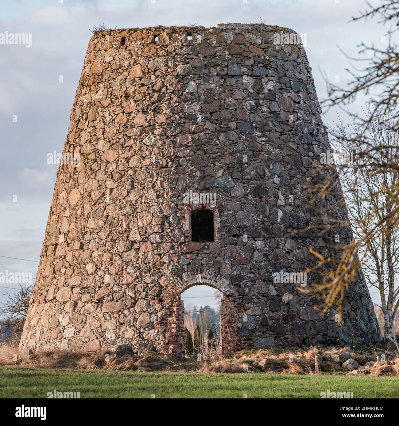 bâtiment abandonné de maçonnerie en pierre de moulin sans porte, vous pouvez voir les poteaux électriques derrière le moulin parce que les deux portes du bâtiment ne sont pas longues Banque D'Images