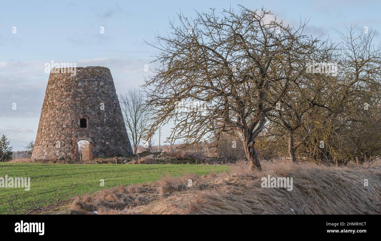 bâtiment abandonné de maçonnerie en pierre de moulin sans porte, vous pouvez voir les poteaux électriques derrière le moulin parce que les deux portes du bâtiment ne sont pas longues Banque D'Images