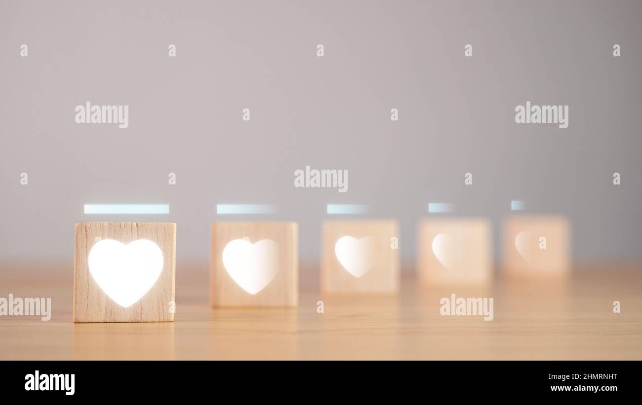 Concept de la Saint-Valentin. Les niveaux d'amour, par rapport à la profondeur de champ, sont dans le graphique à barres. Les blocs cubes en bois ont un effet visuel en forme de coeur blanc. Banque D'Images