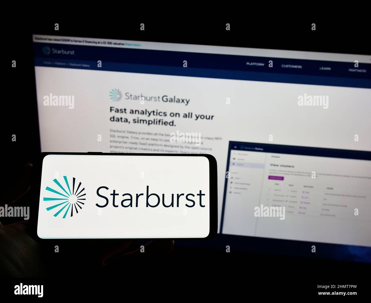 Personne tenant un téléphone portable avec le logo de la société américaine de logiciel Starburst Data Inc. À l'écran devant la page Web d'affaires. Mise au point sur l'affichage du téléphone. Banque D'Images