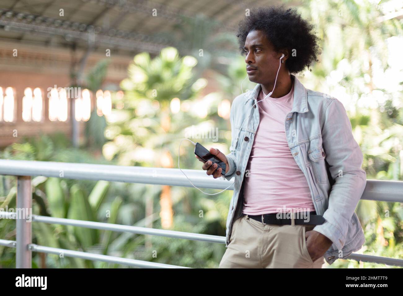 Un jeune homme afro-américain écoute de la musique depuis son téléphone. Espace pour le texte. Banque D'Images