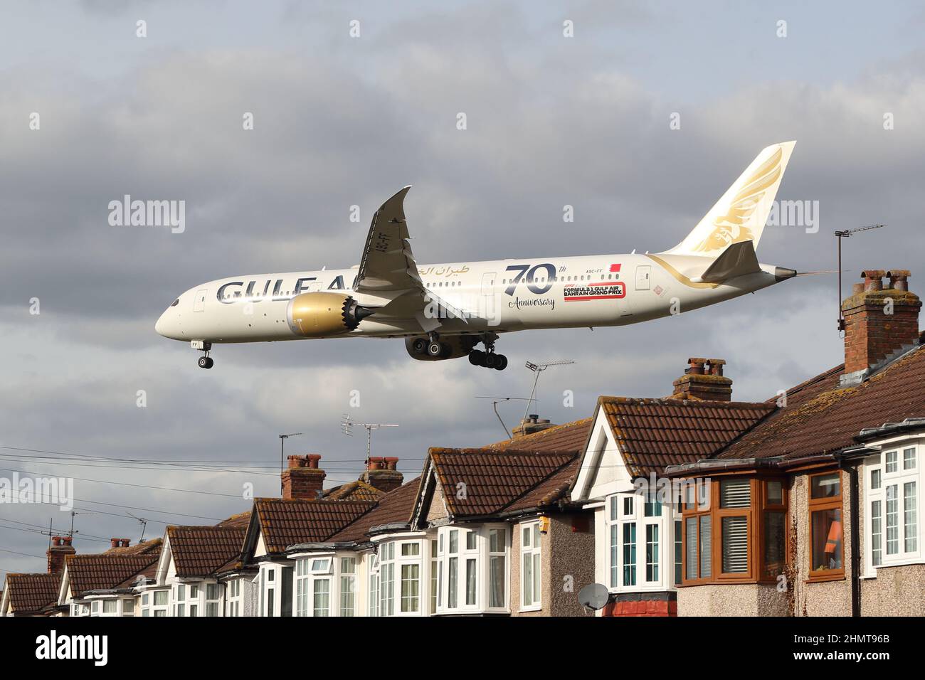 Un Boeing 787-9 Dreamliner de Gulf Air s'approche de l'aéroport d'Heathrow en survolant les toits de maisons de Myrtle Avenue, Londres, Royaume-Uni Banque D'Images