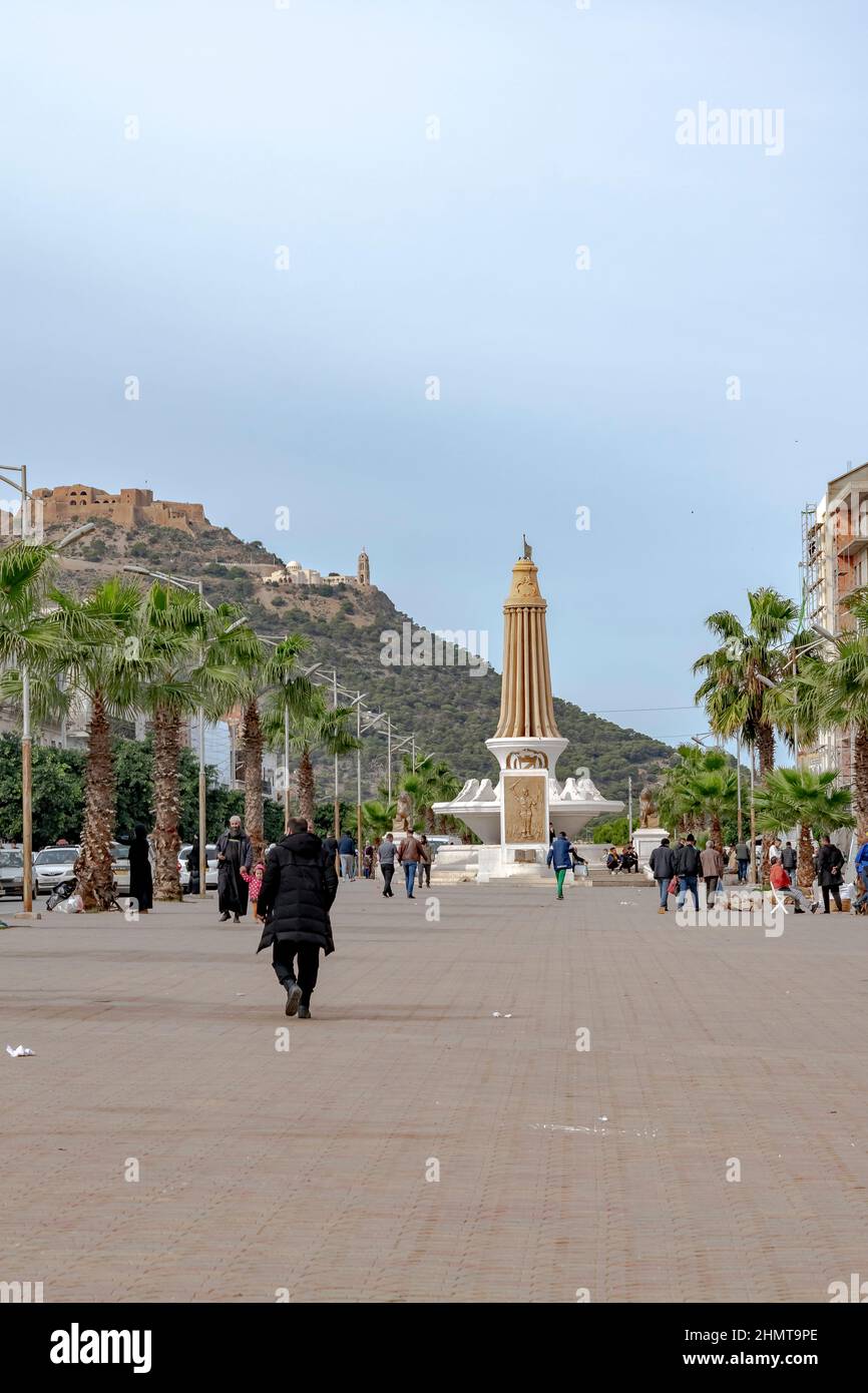 Oran, Algérie: Vue à angle bas du fort de Santa Cruz et de la chapelle vue de Tahtaha Monument aux morts, Mdina Djdida. Personnes marchant et palmiers sur eac Banque D'Images