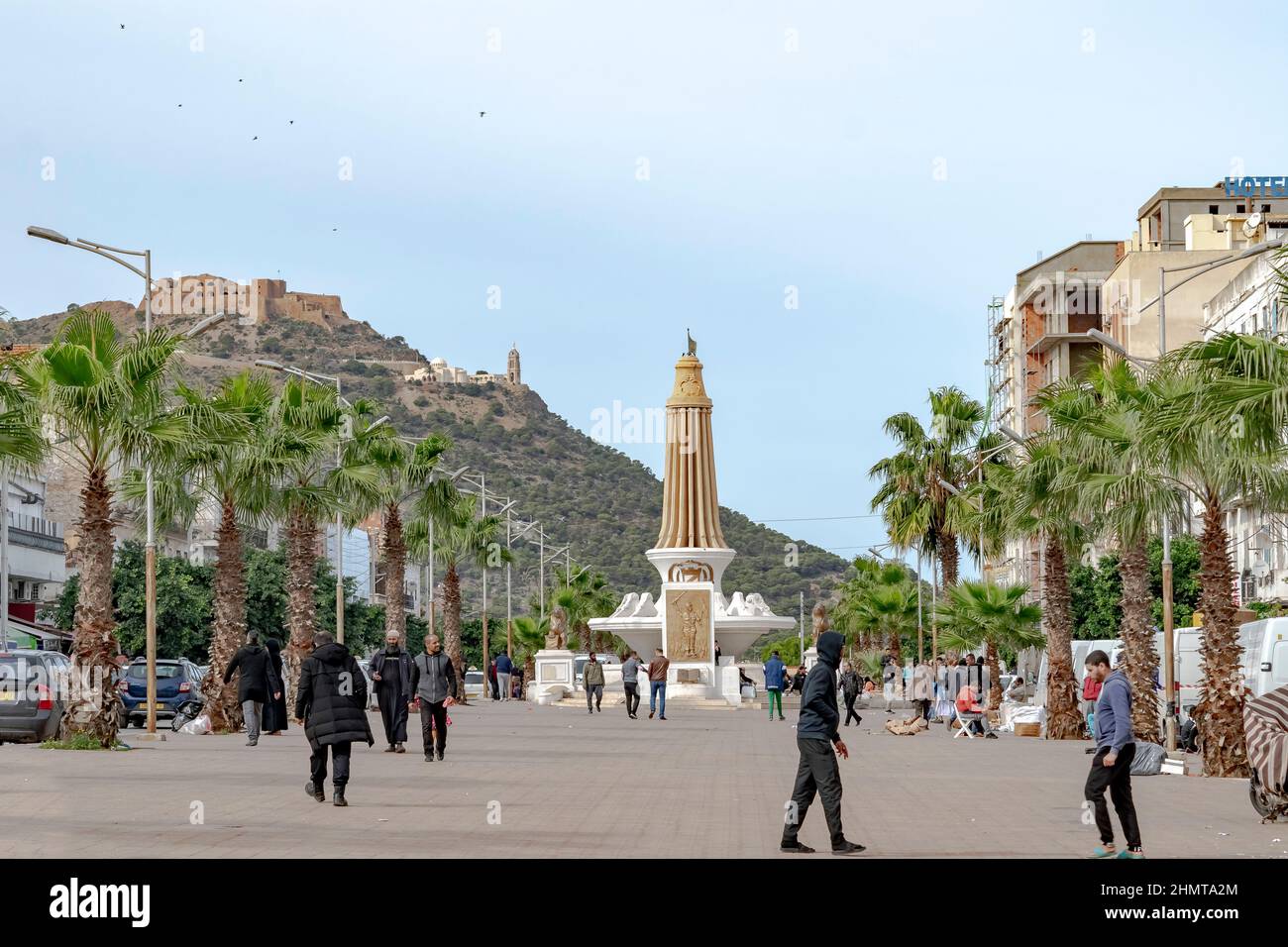 Oran, Algérie: Vue à angle bas du fort de Santa Cruz et de la chapelle vue de Tahtaha Monument aux morts, Mdina Djdida. Personnes marchant et palmiers sur eac Banque D'Images