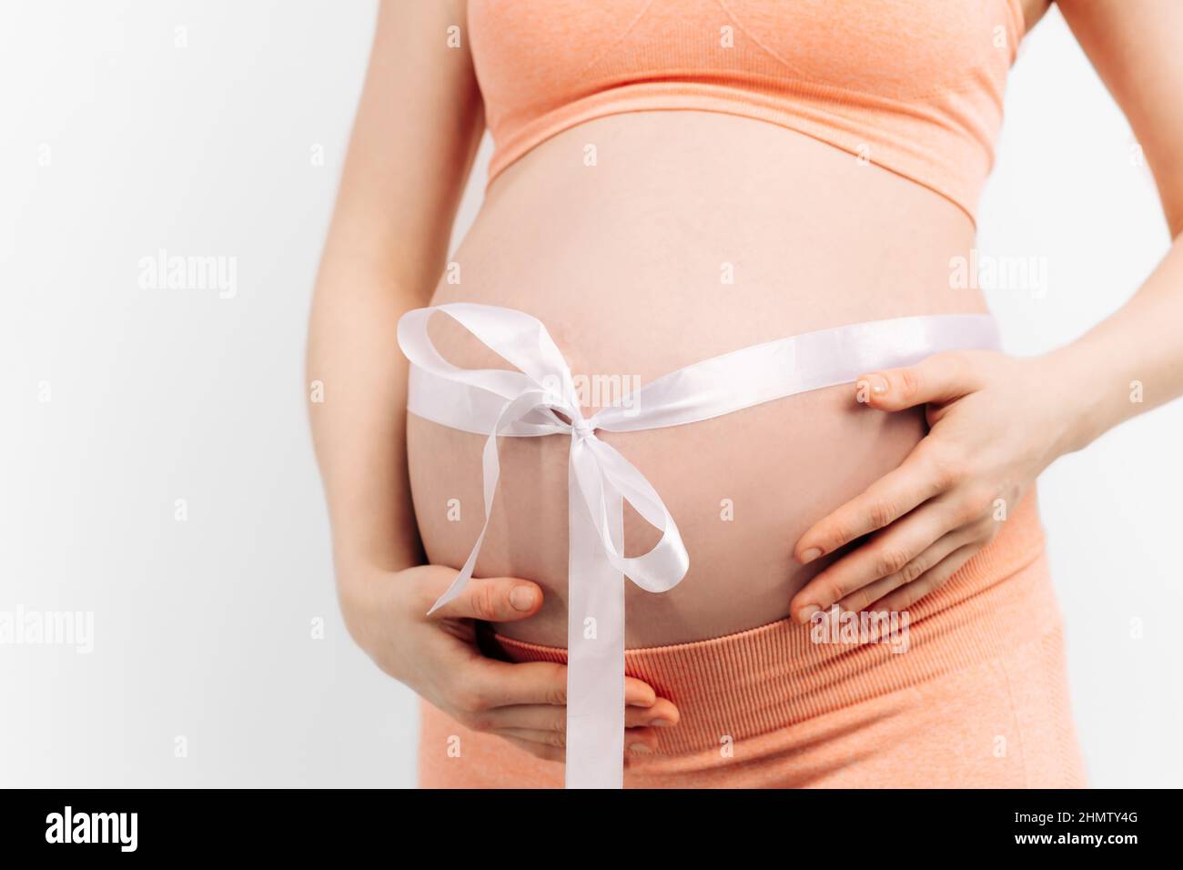 femme enceinte avec un ruban adhésif sur son ventre touchant son ventre .  Femme s'attendant à un bébé, femme enceinte heureuse avec un gros ventre.  Le concept de grossesse Photo Stock -