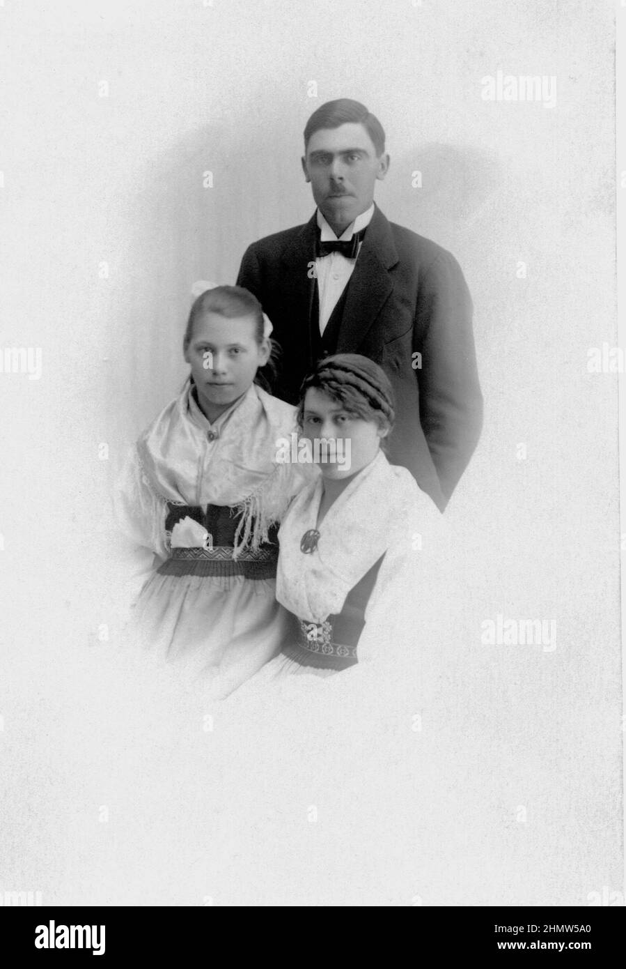 20th siècle authentique photo vintage de jeune homme en costume et noeud papillon et deux jeunes femmes en costume traditionnel, Suède Banque D'Images