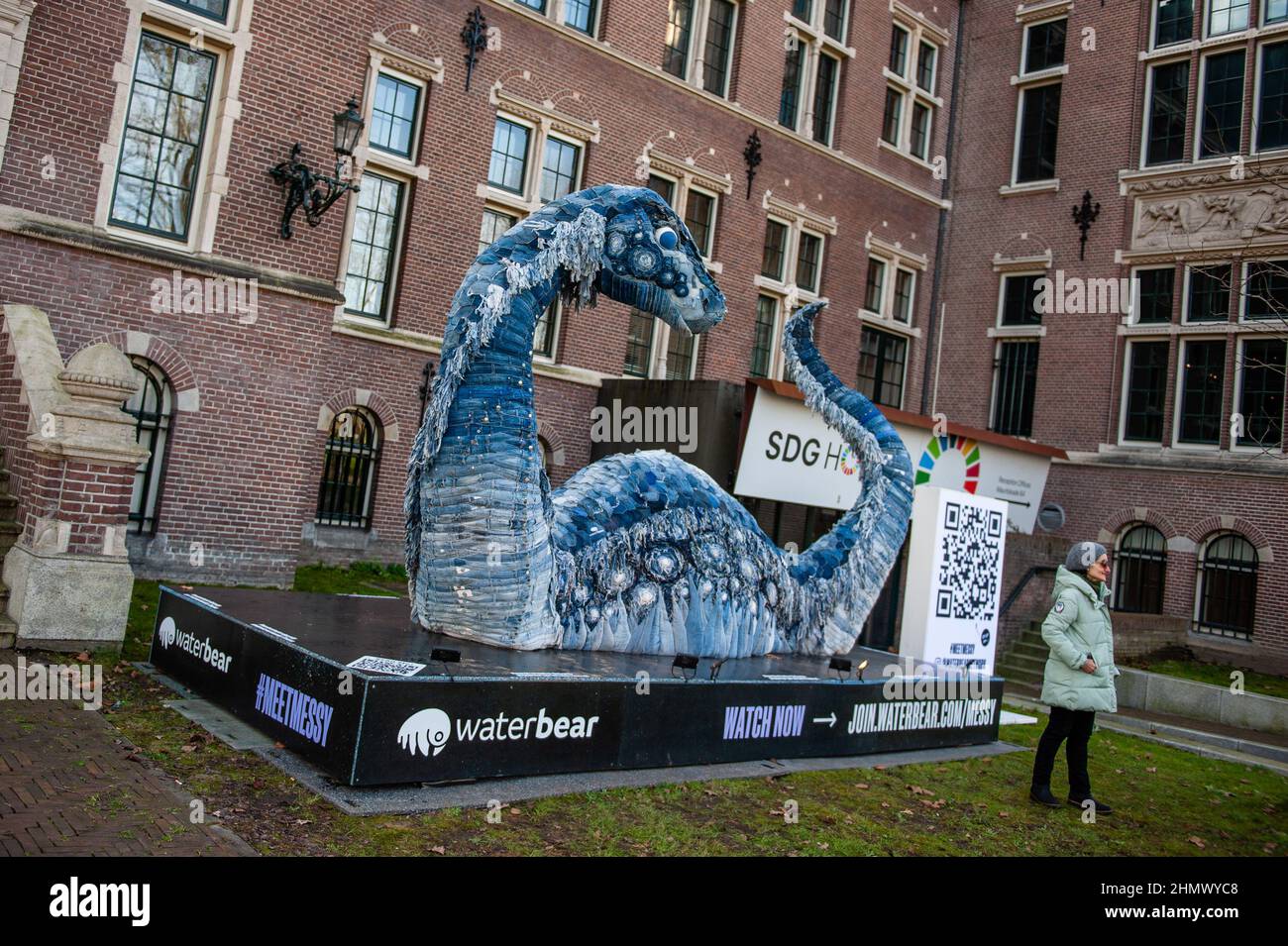 Une femme est vue posant devant le désordre, la sculpture de monstre de Ness de la CdP. Lors de la célébration du COP26 à Glasgow, WaterBear s'est associé à l'artiste Billie Achilleos et à la marque circulaire de denim MUD Jeans pour créer une sculpture du légendaire monstre marin d'Écosse. En raison de la semaine néerlandaise de la circularité, cette sculpture durable peut être vue devant la TENUE du bâtiment du Royal Tropical Institute d'Amsterdam pour poursuivre sa mission de souligner le besoin critique d'une économie circulaire. 5 mètres de long et avec la peau faite de 800 jeans recyclés, le désordre est un rappel frappant du monstrou Banque D'Images