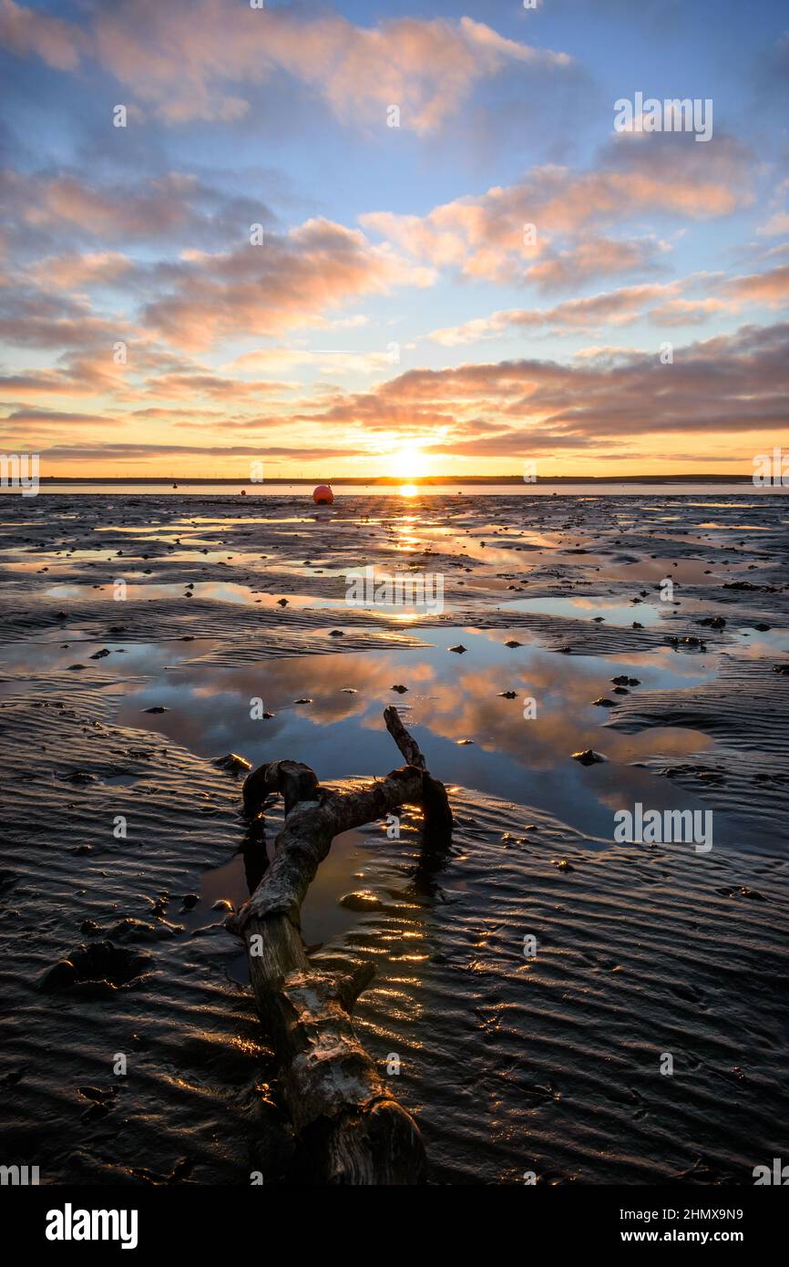 Coucher de soleil lumineux et coloré sur la plage d'hiver capturé au canal de Walney, depuis le rivage de l'île Roa, Rampside, barrow in furness, Lake District, Cumbria, ROYAUME-UNI Banque D'Images