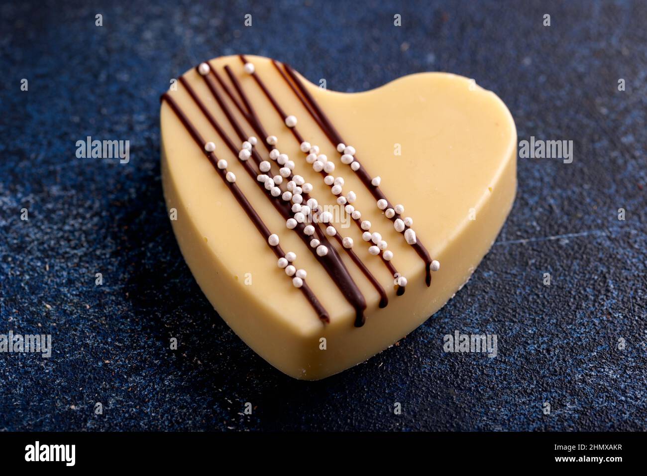 Délicieux coeur en chocolat blanc sur table rustique bleue. Banque D'Images