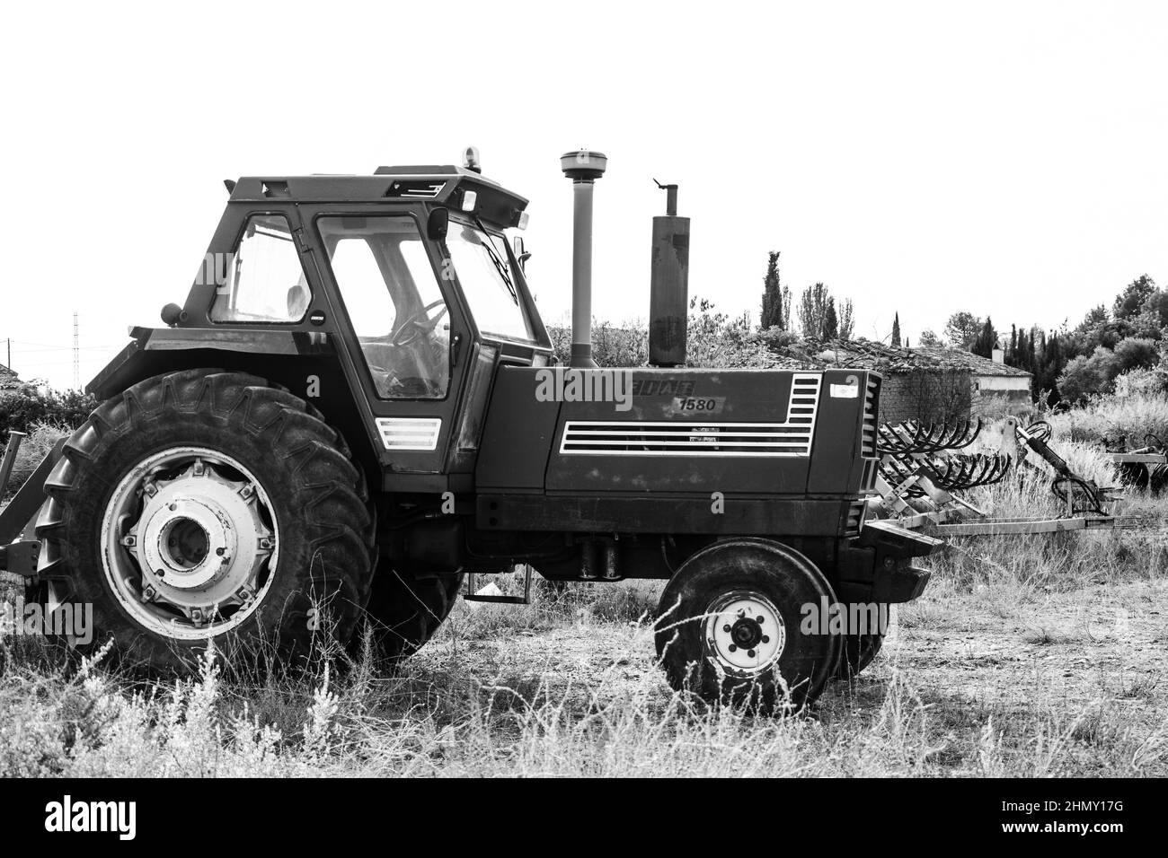 Photo en noir et blanc d'un vieux tracteur Fiat rouge model1580 stationné dans le camp Banque D'Images