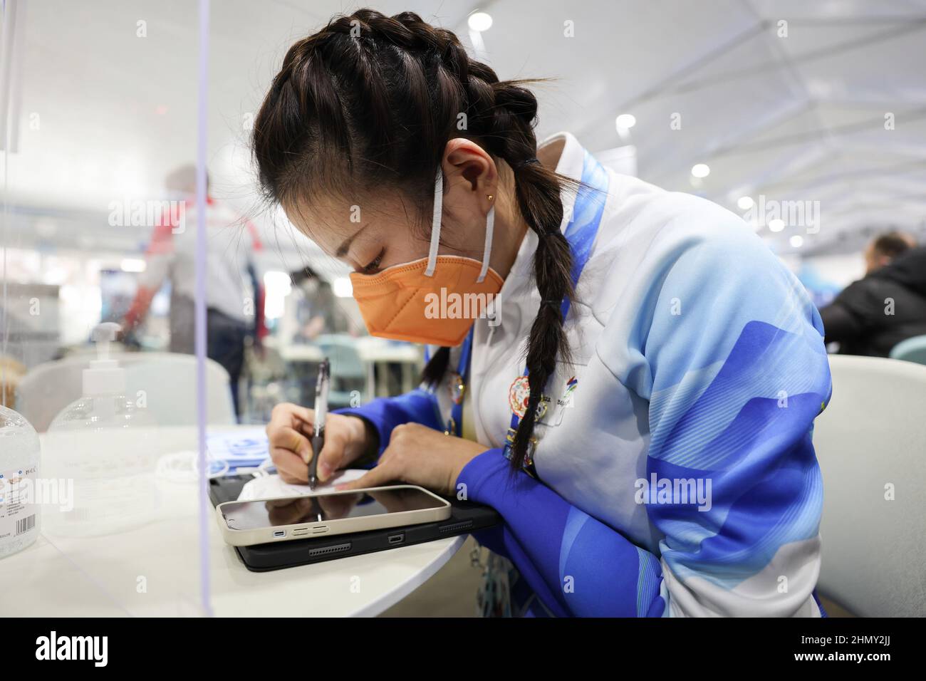 (220213) -- ZHANGJIAKOU, 13 février 2022 (Xinhua) -- Han Zhebin, volontaire des Jeux Olympiques d'hiver de Beijing 2022, tire sur le masque Bing Dwen Dwen peint à la main au Centre national de biathlon de Zhangjiakou, dans la province de Hebei, en Chine du Nord, 11 février 2022. « J'espère que de cette façon, des journalistes du monde entier pourront ressentir l'enthousiasme et l'amitié de nos bénévoles. » Lors de l'atelier médiatique du Centre national de biathlon, le volontaire Han Zhebin peint à la main Bing Dwen Dwen Mask a été accueilli par des journalistes étrangers. Le volontaire Han Zhebin est du College of Art and Design de l'Université de Yanshan. Al Banque D'Images