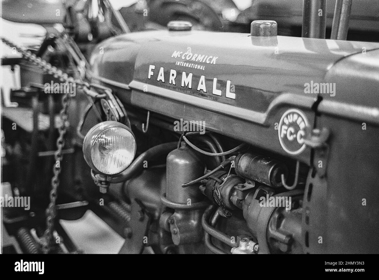 Photo en niveaux de gris d'une exposition de tracteurs dans le parc, d'un ancien tracteur et d'un détail du moteur Banque D'Images