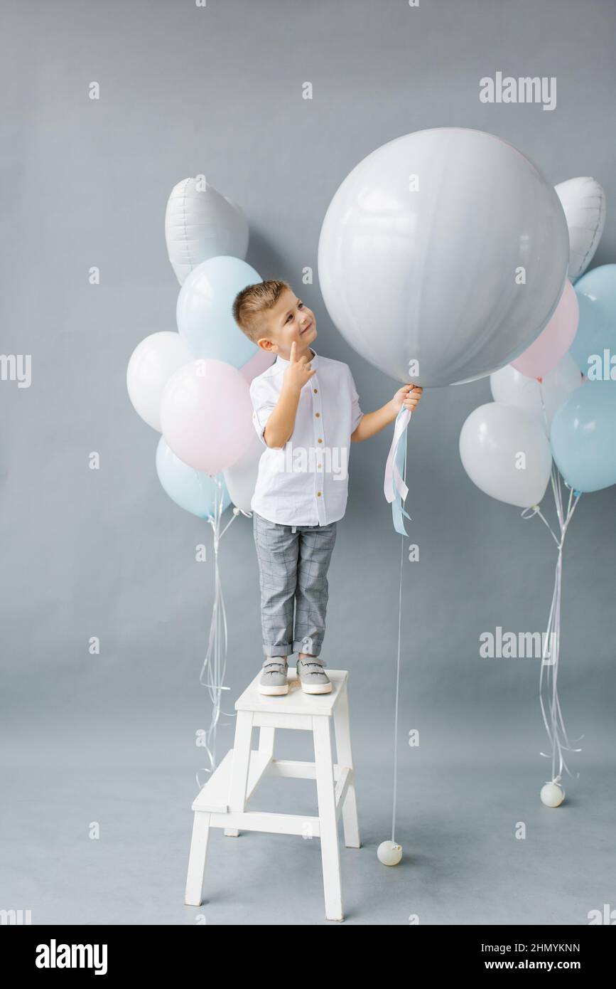 Fête de révélation de genre. Un enfant de quatre ans tient un ballon entre ses mains pour découvrir le sexe de l'enfant à naître dans la famille. Anniversaire de l'enfant Banque D'Images