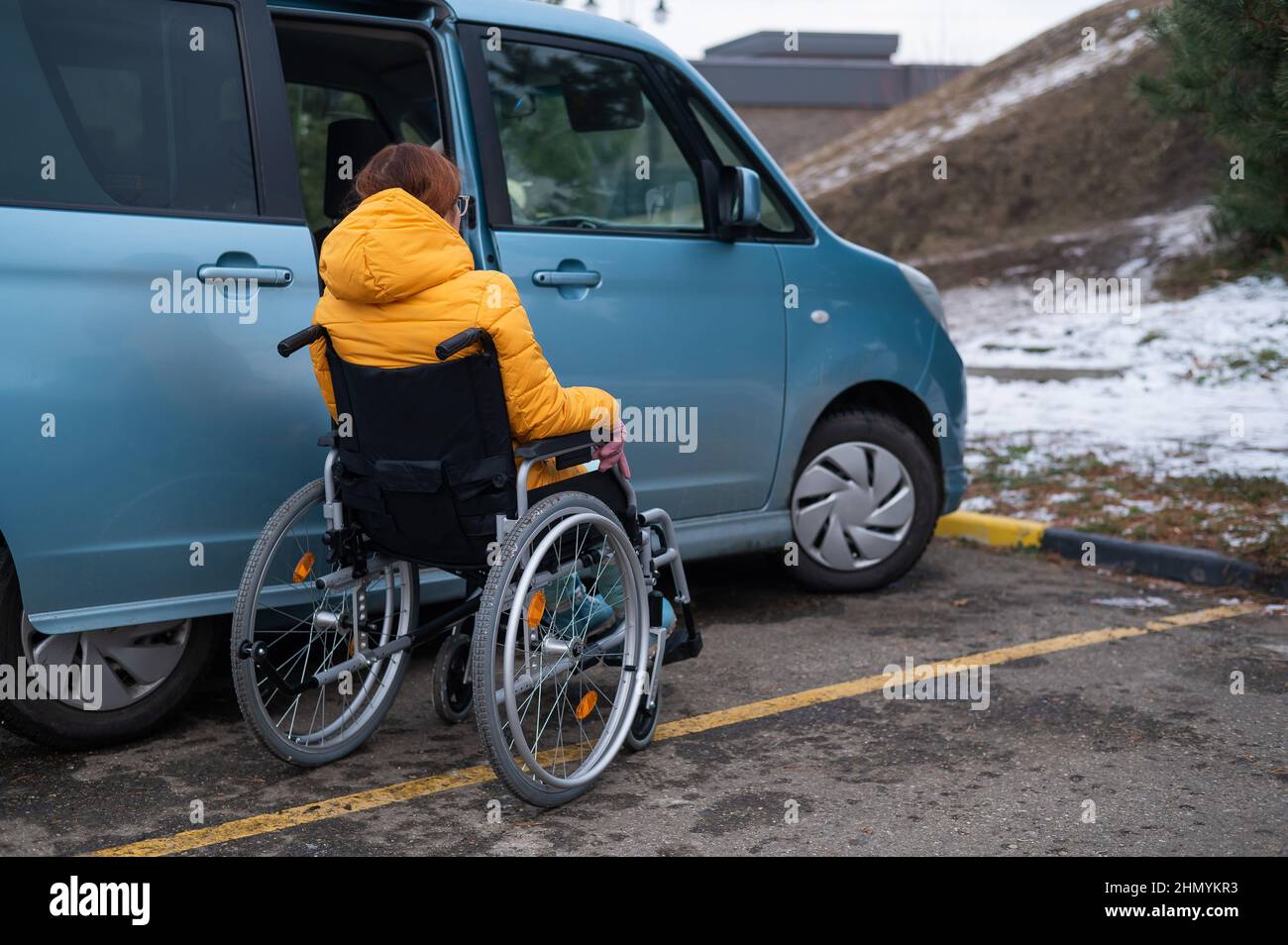 Une femme caucasienne en fauteuil roulant entre dans la voiture. Banque D'Images