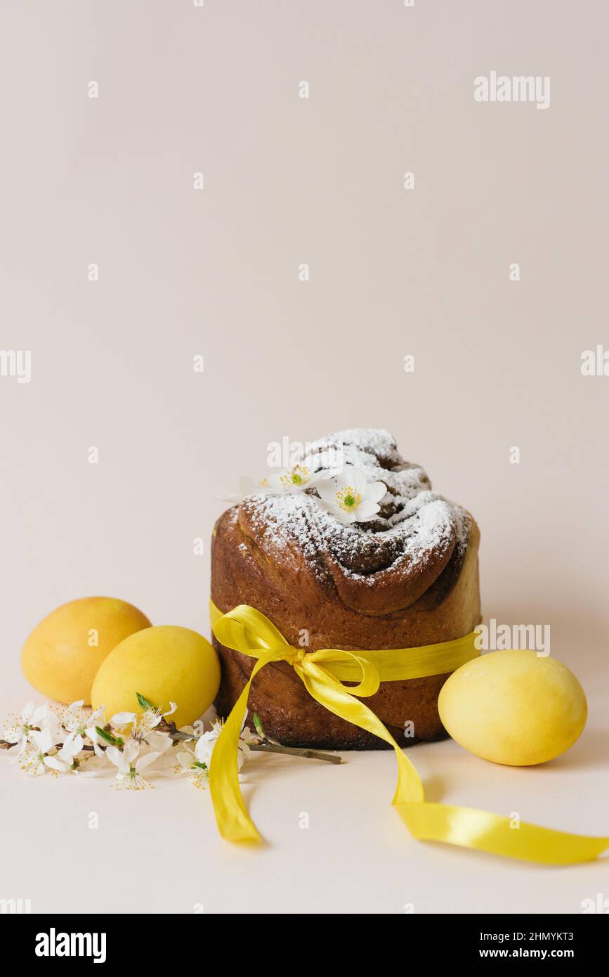 Gâteau de Pâques kraffin à la cannelle et au sucre en poudre.Gros plan d'une tarte maison avec des œufs de couleur jaune et de caille Banque D'Images