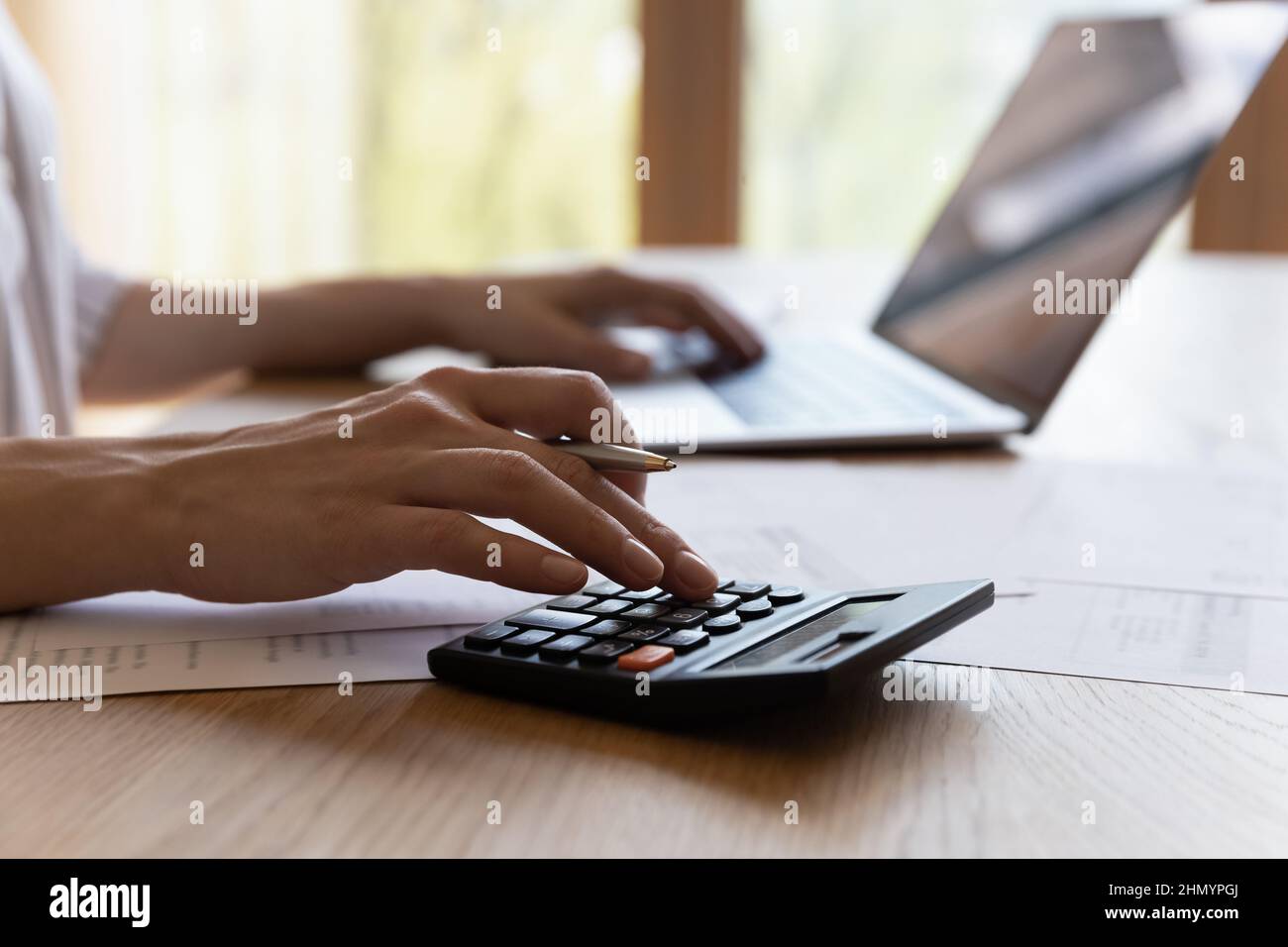 Gros plan jeune femme en culture calculant les dépenses du ménage. Banque D'Images
