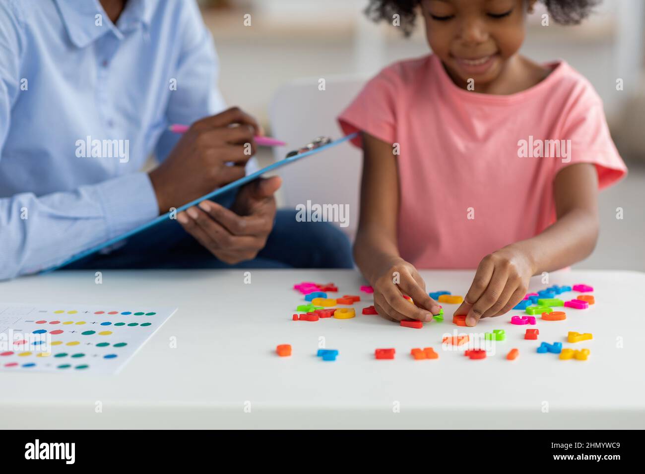 Enfant afro-américain mignon jouant avec des lettres colorées Banque D'Images