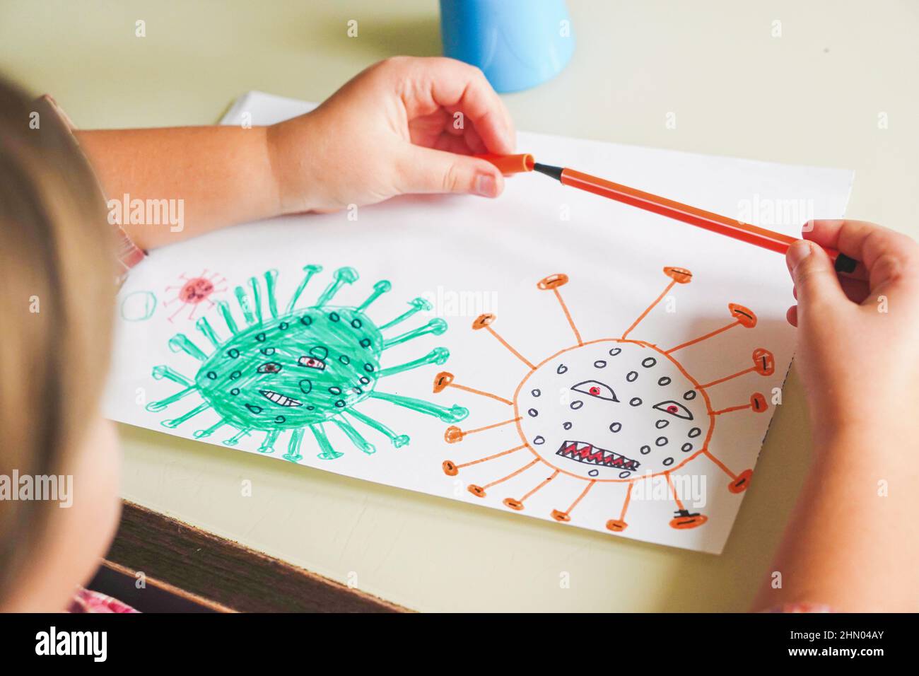 Mignon petite fille tient sa molécule de dessin Corona virus Omicron par feutre stylos. Maladie infectieuse et DEA mondiale en cas d'épidémie de coronavirus de santé mondiale Banque D'Images