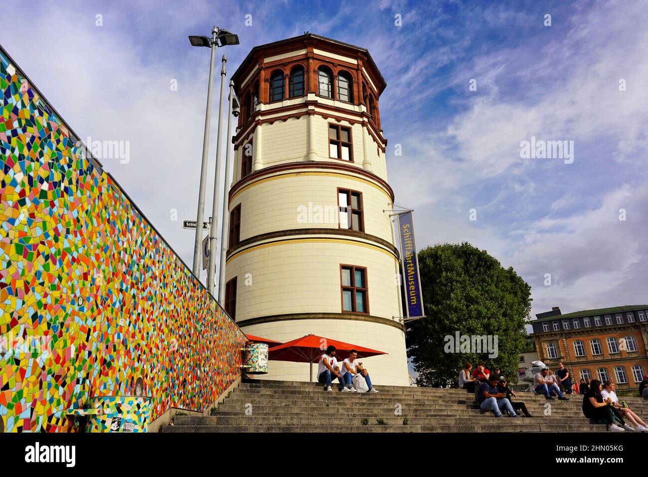 La tour historique du château de Düsseldorf au bord du Rhin, qui est aujourd'hui un musée maritime. Sur le côté gauche : mur de mosaïque par Hermann-Josef Kuhna. Banque D'Images