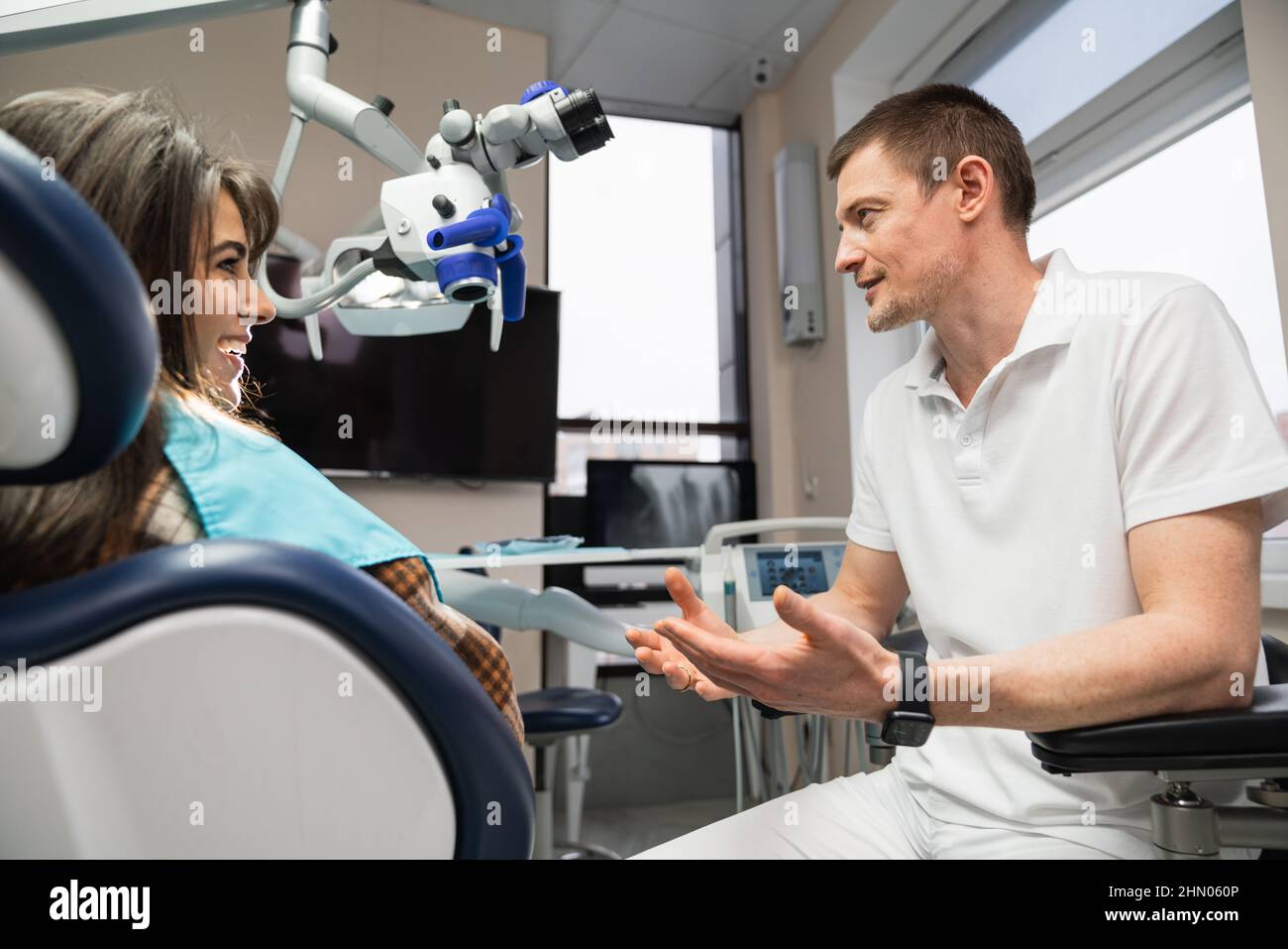 Le dentiste communique avec le patient au cabinet dentaire à l'aide d'une tablette numérique Banque D'Images
