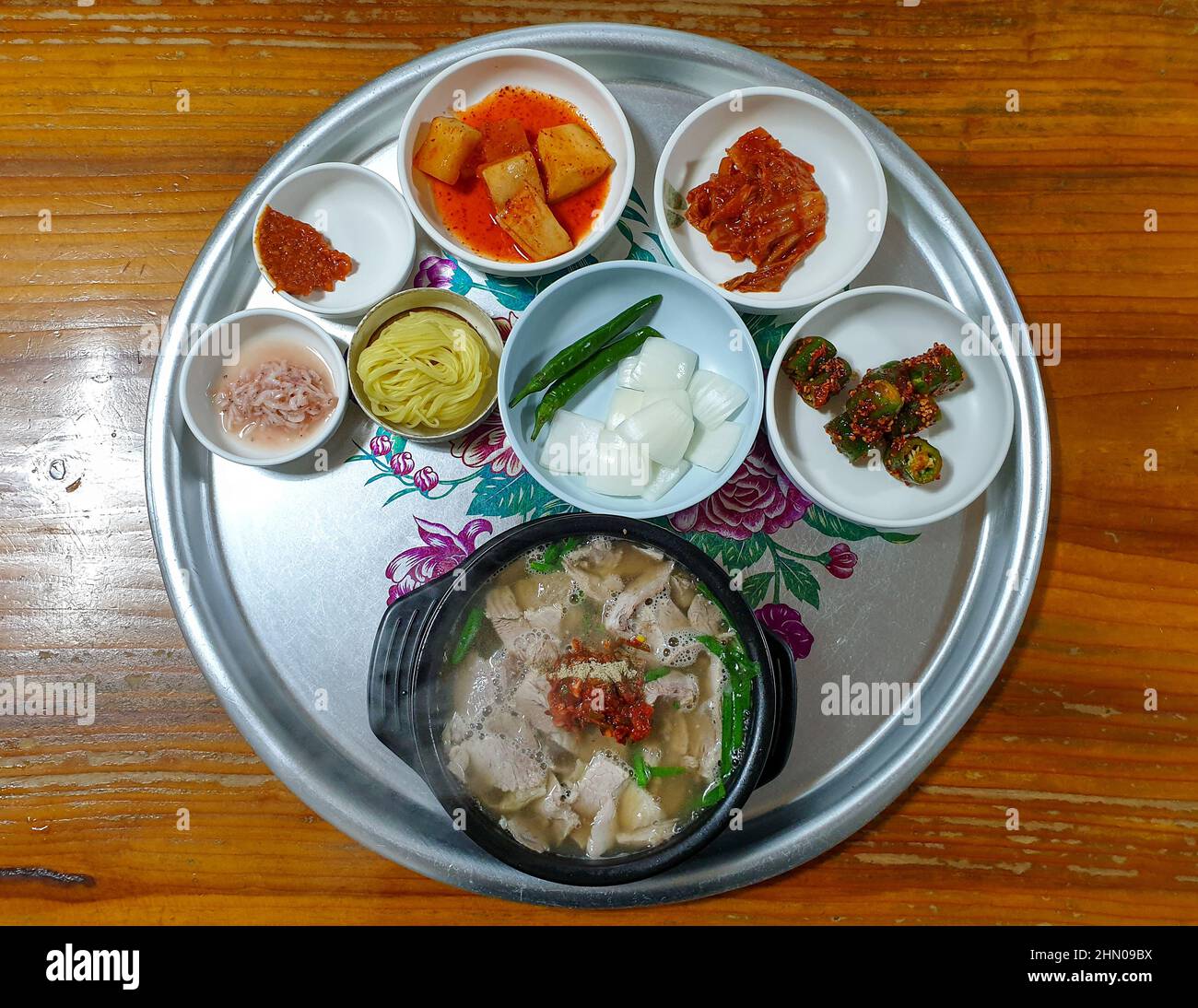 Dwaeji-gukbap, une soupe populaire sud-coréenne faite avec du porc, de la sauce soja, du vin de riz, de l'huile de sésame et du bouillon d'os. Servi avec une variété de plats d'accompagnement. Banque D'Images