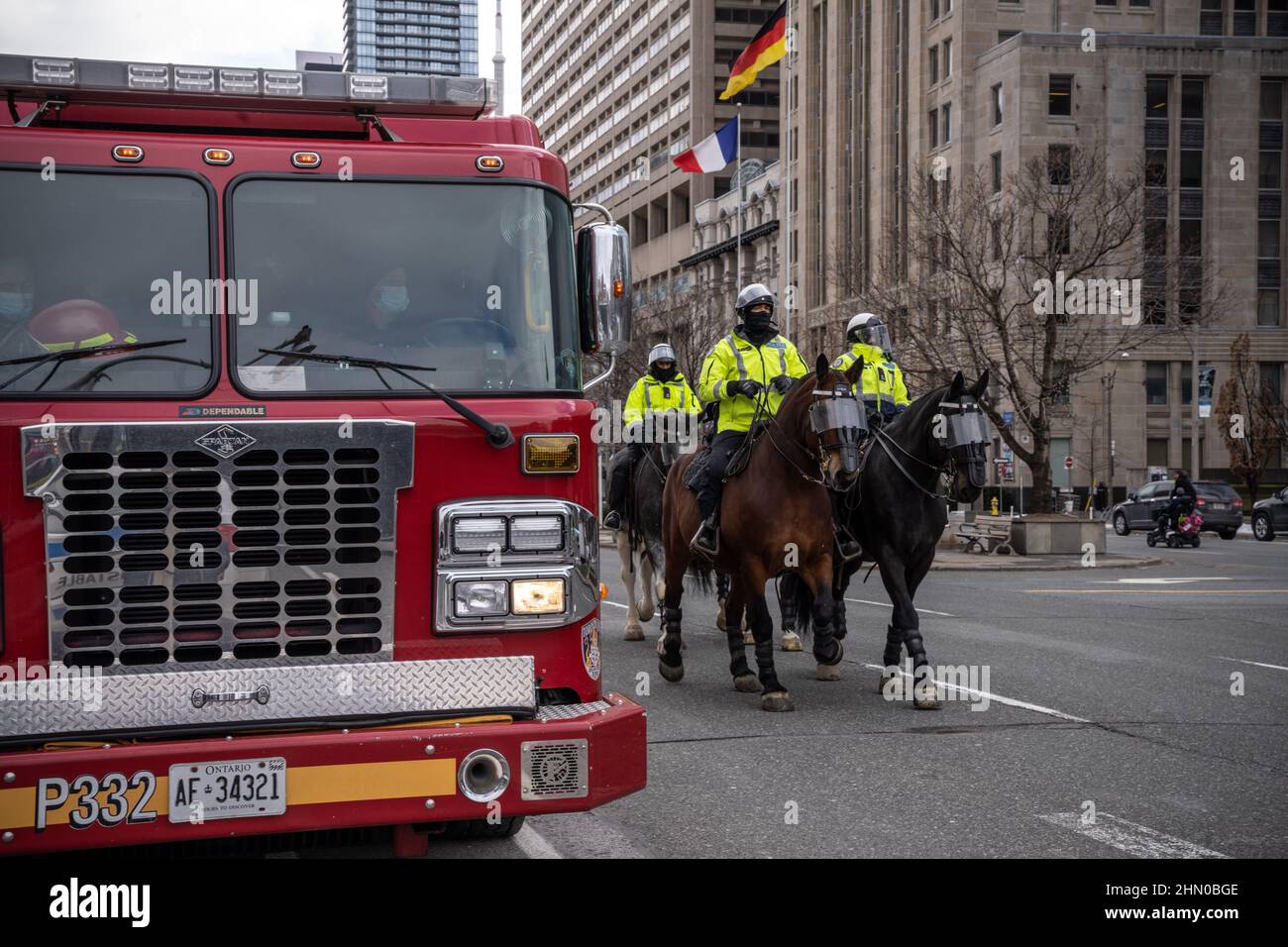 Toronto, Canada. 12th févr. 2022. Les policiers montés à Toronto sont vus passer par un camion d'incendie, avec de multiples fermetures de routes en prévision des manifestations.des manifestants de convoi de camionneurs se réunissent à Queen's Park, à Toronto, pour la deuxième fin de semaine consécutive en solidarité avec des manifestations anti-mandat. Elle intervient après que la province ait déclaré l'état d'urgence en ce qui concerne les blocus en cours, la police de Toronto ayant mis en place des fermetures de routes dans toute la ville. Crédit : SOPA Images Limited/Alamy Live News Banque D'Images