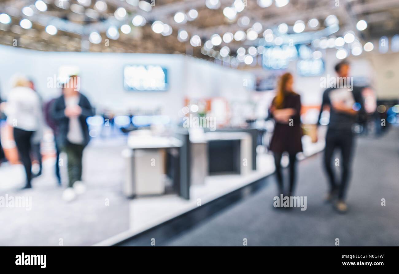 Personnes marchant sur un stand de salon, fond générique avec un effet de flou appliqué Banque D'Images