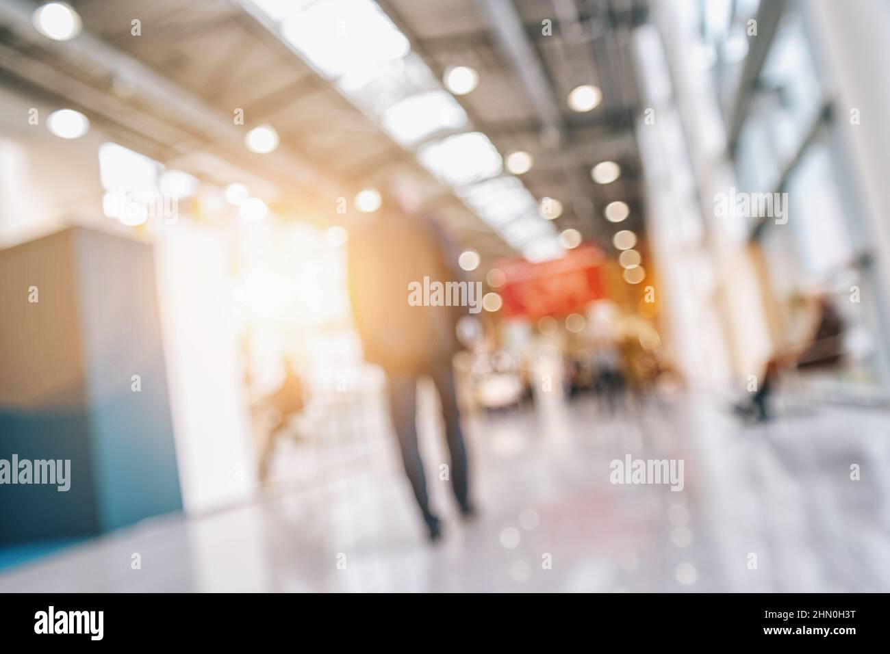 Personnes marchant dans une salle de salon avec des stands, fond générique avec un effet de flou appliqué Banque D'Images