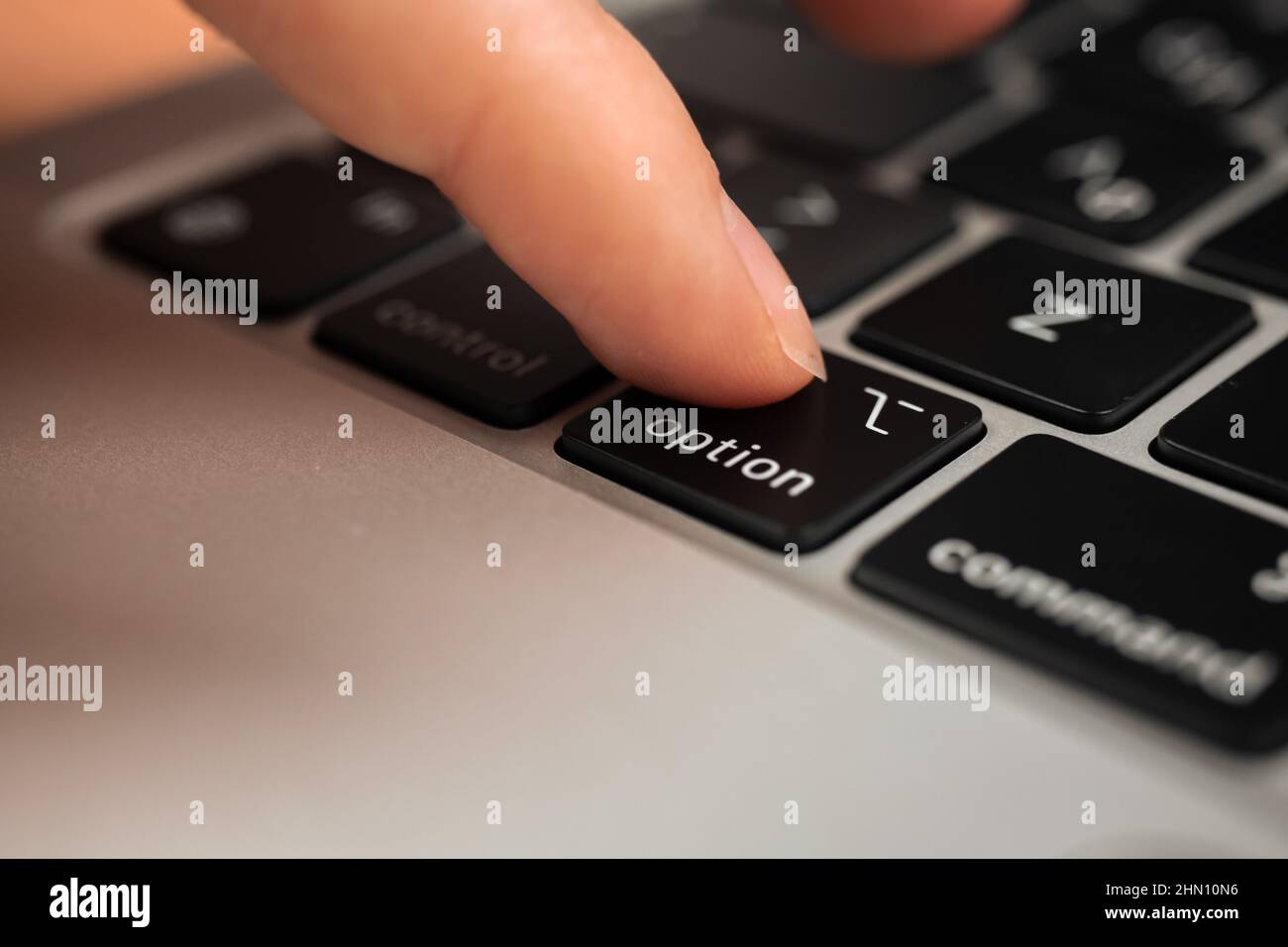 Appuyez à la main sur la touche option du clavier moderne de l'ordinateur  portable. Fermeture du panneau d'option et du symbole Photo Stock - Alamy