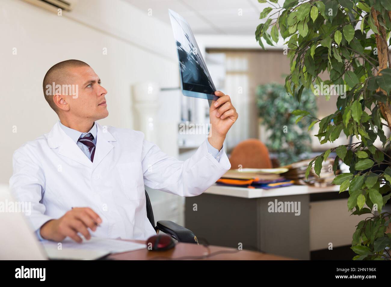 Médecin de sexe masculin examinant les rayons X à la clinique Banque D'Images